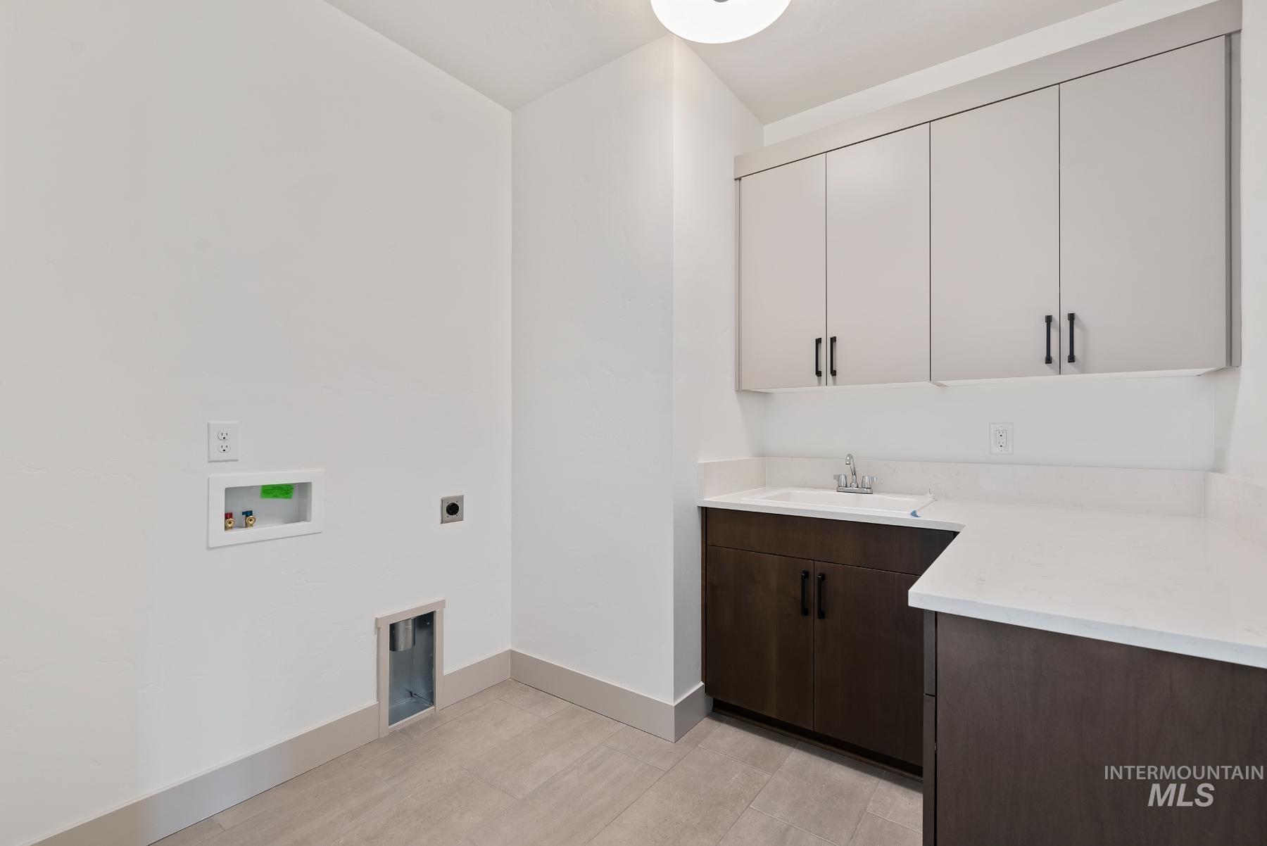 Washroom featuring electric dryer hookup, washer hookup, and cabinet space