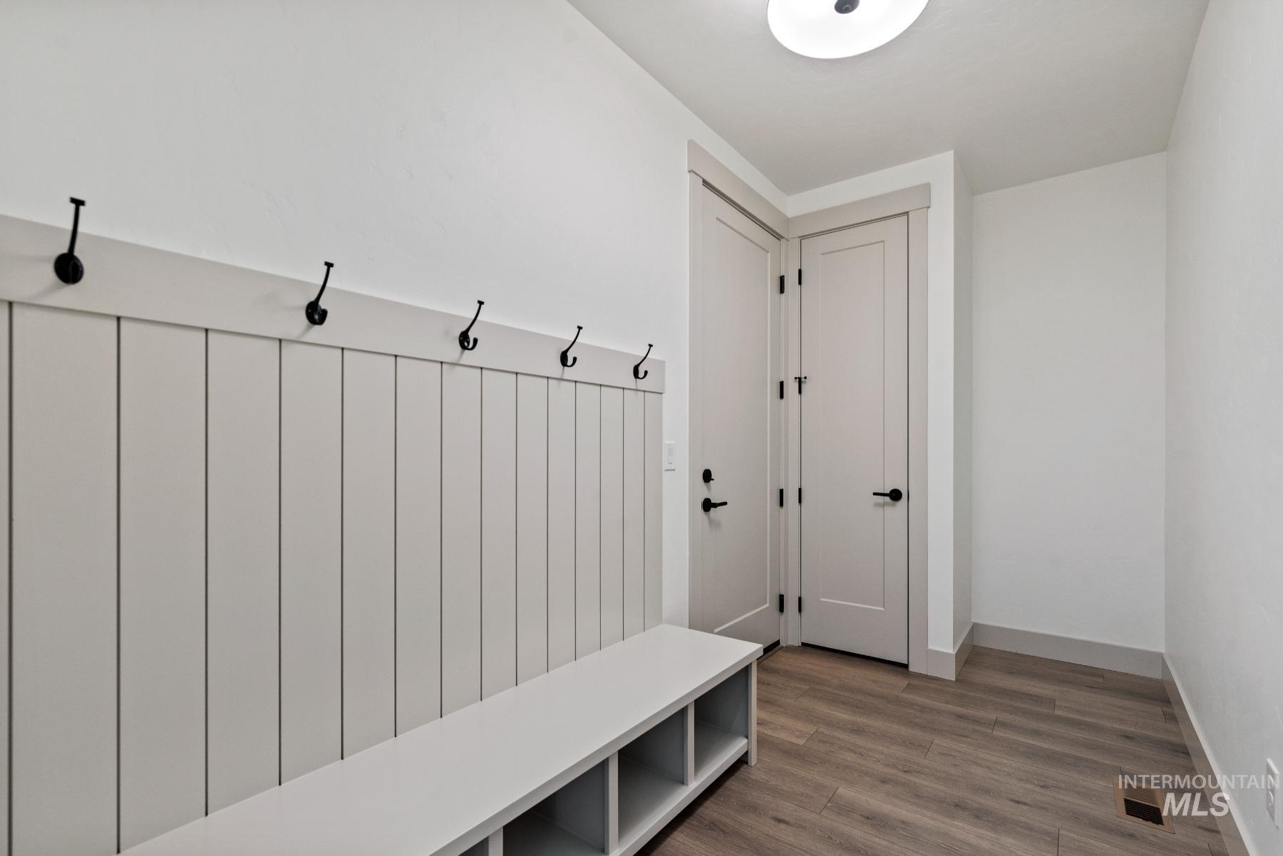 Mudroom featuring wood finished floors and radiator heating unit