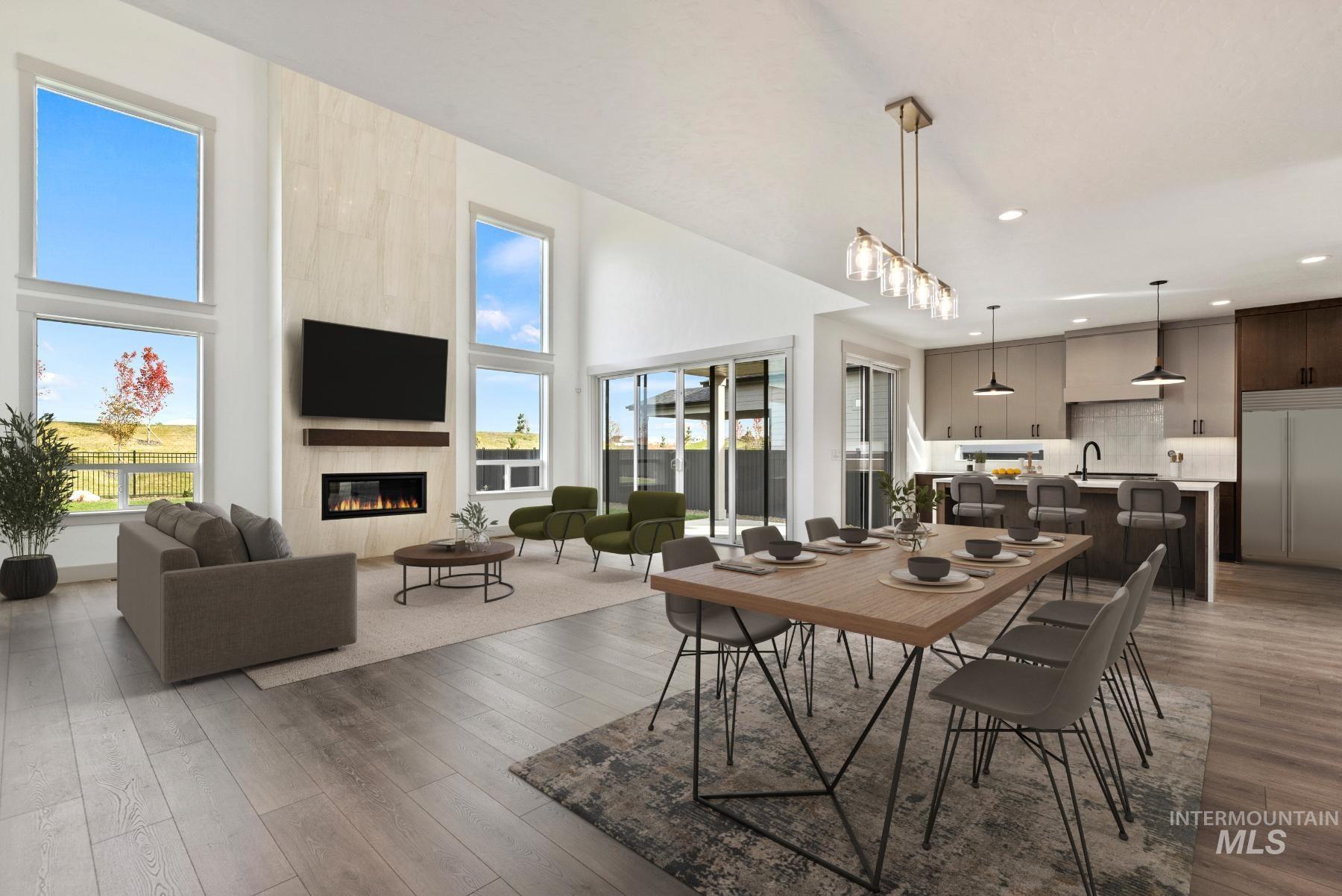Dining area featuring light wood finished floors, a fireplace, a high ceiling, and recessed lighting