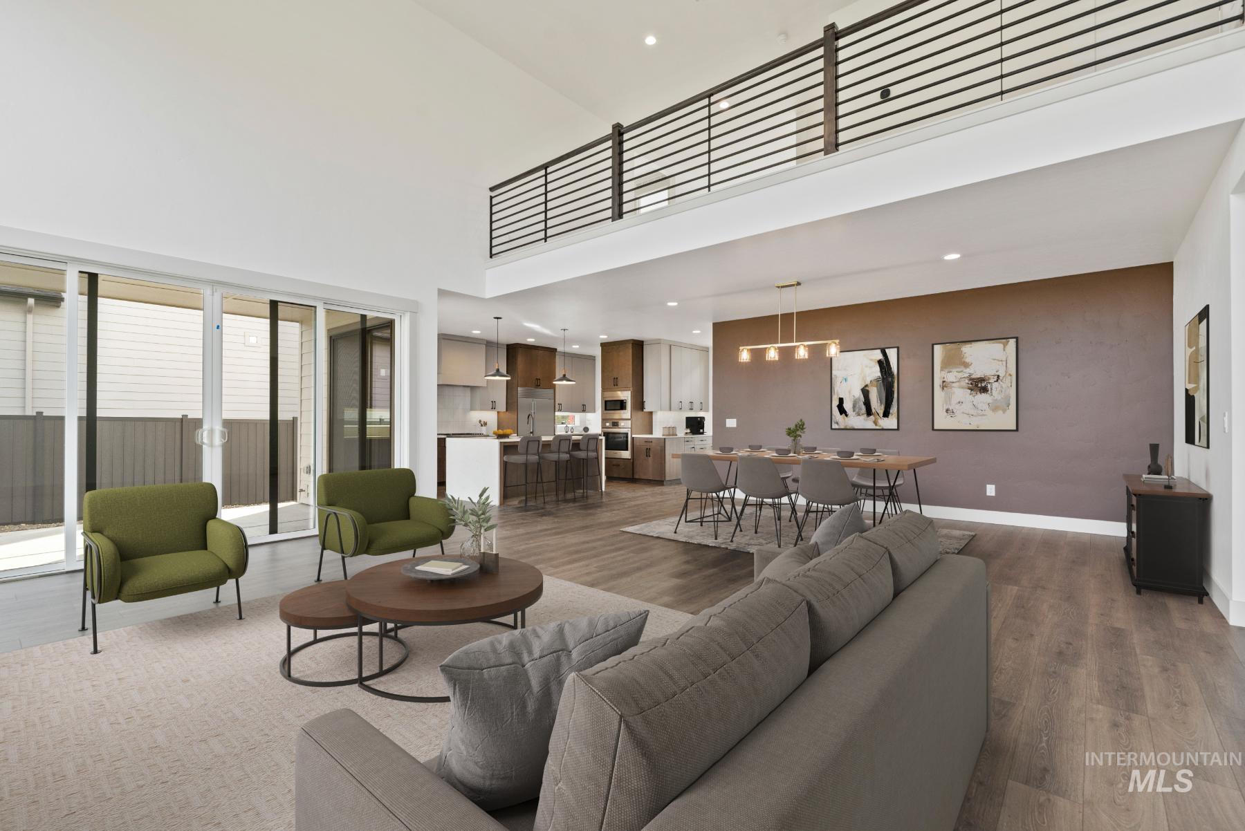 Living area featuring wood finished floors, a towering ceiling, and recessed lighting