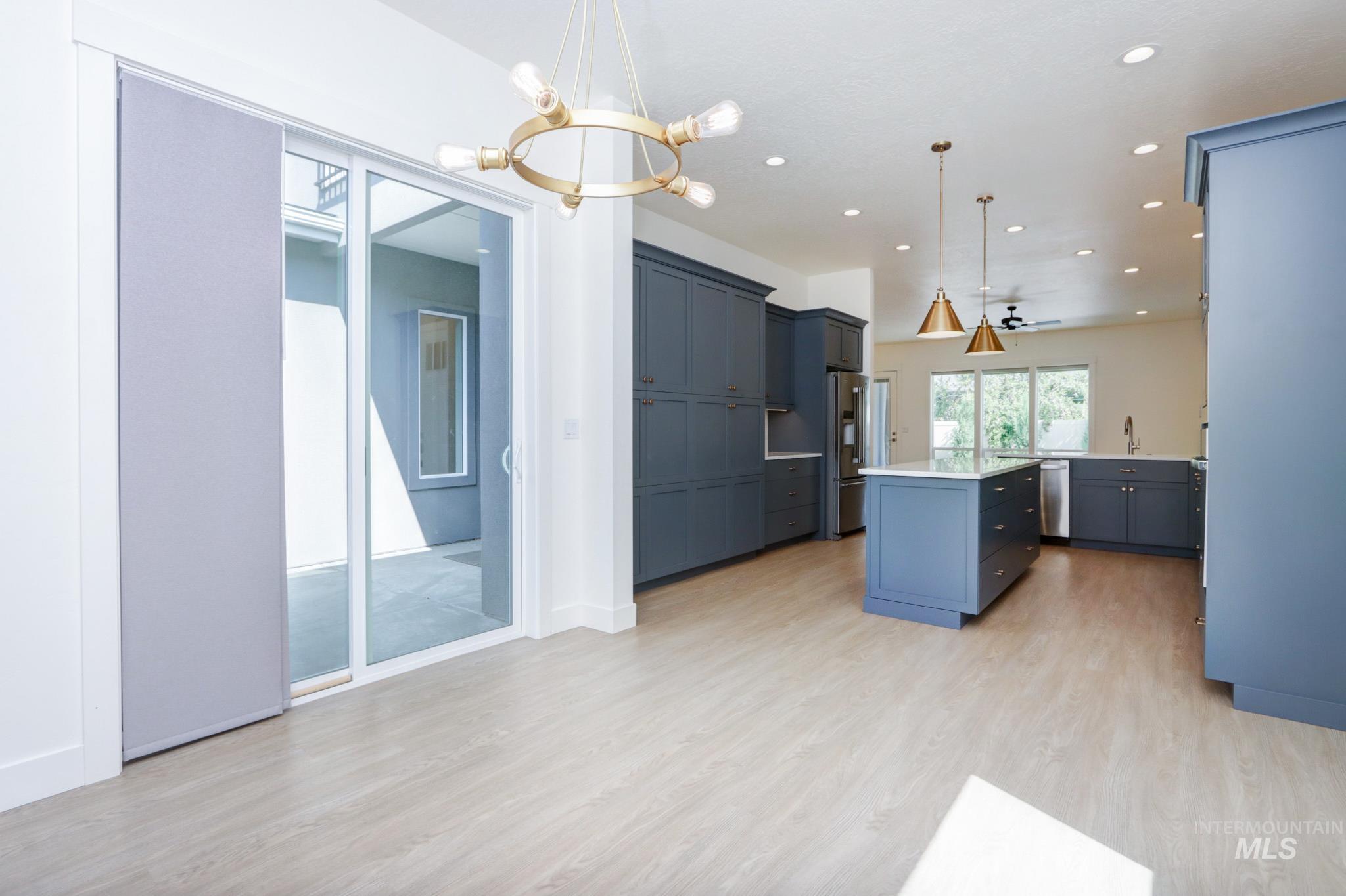 Kitchen with a center island, light wood-type flooring, light countertops, recessed lighting, and decorative light fixtures