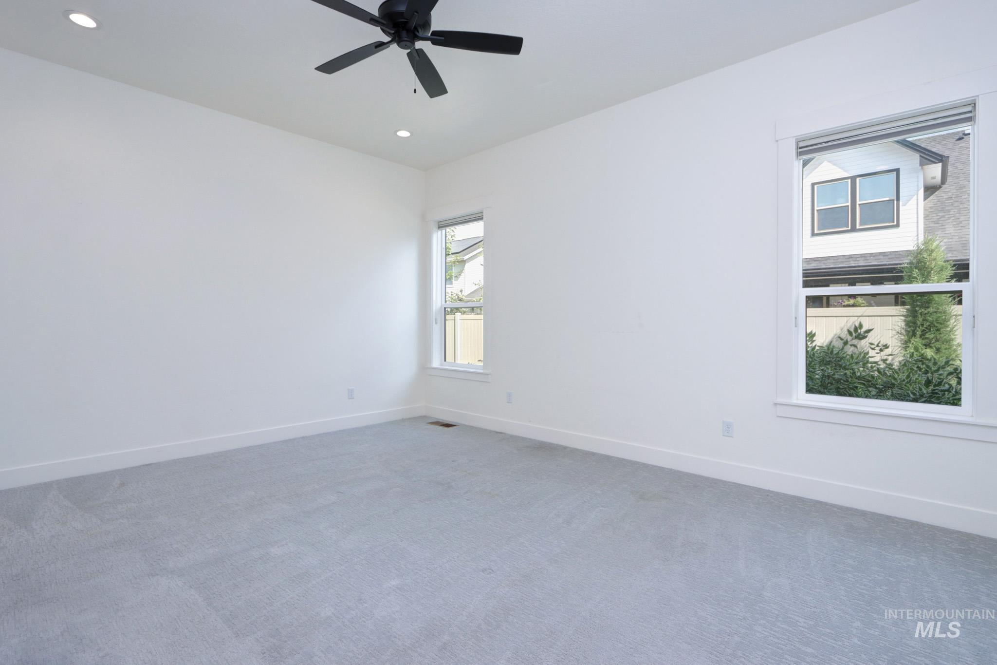 Carpeted spare room featuring recessed lighting and a ceiling fan