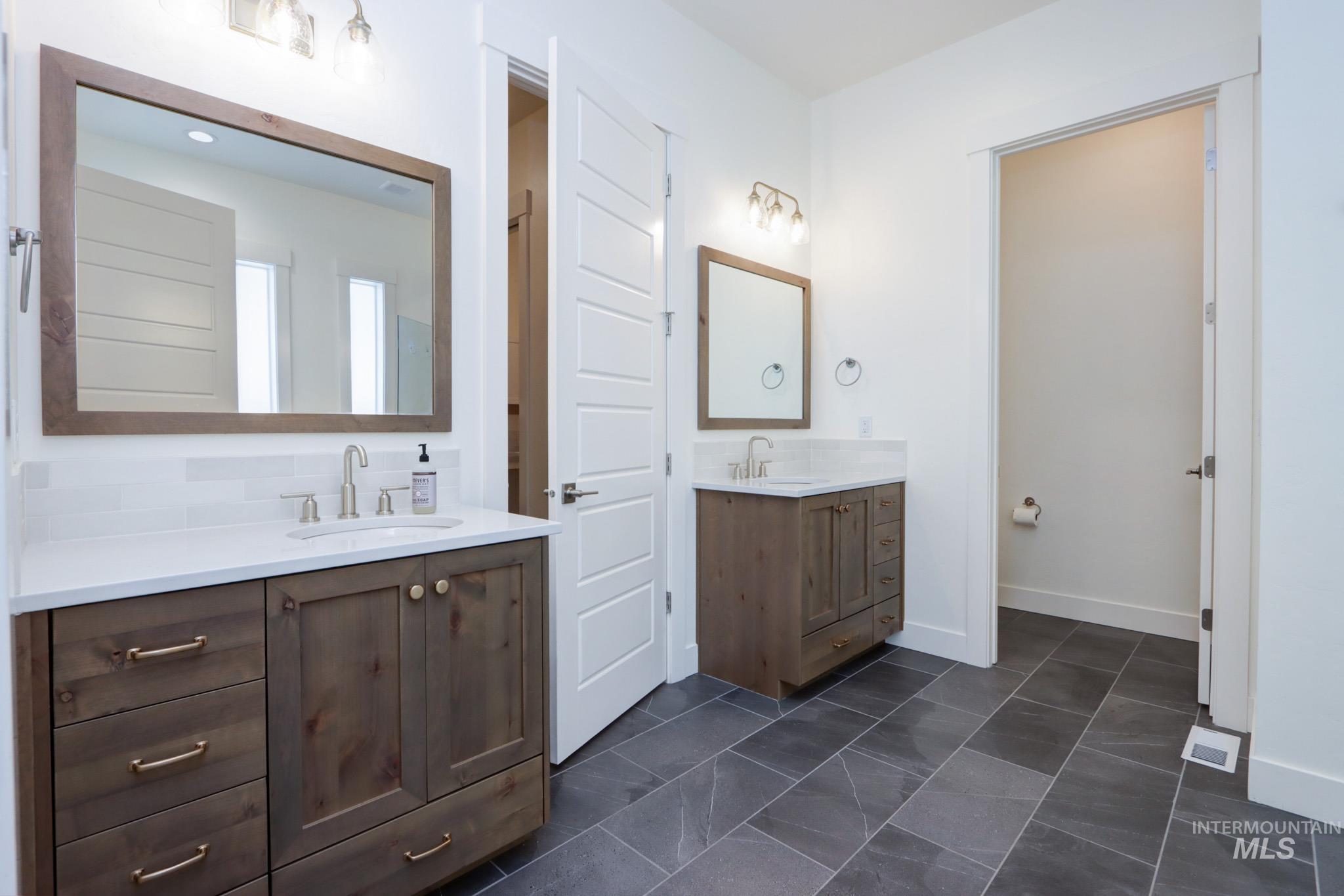Bathroom with two vanities and baseboards