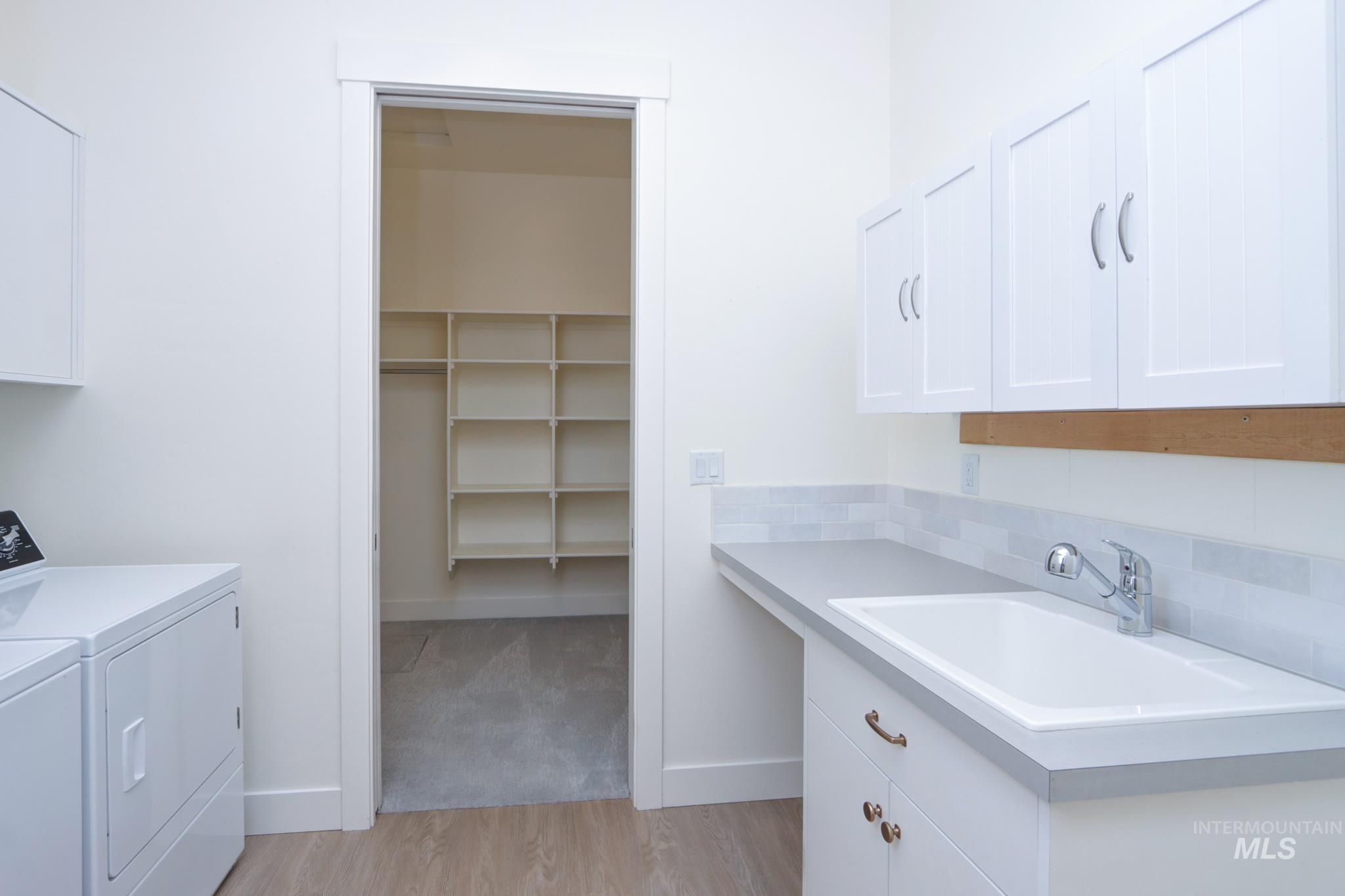Laundry area featuring cabinet space, washer and dryer, and light wood-type flooring
