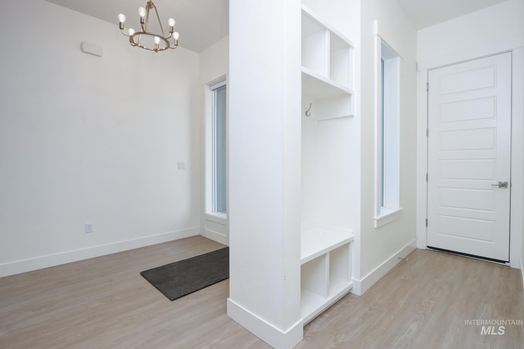 Mudroom with a chandelier and wood finished floors