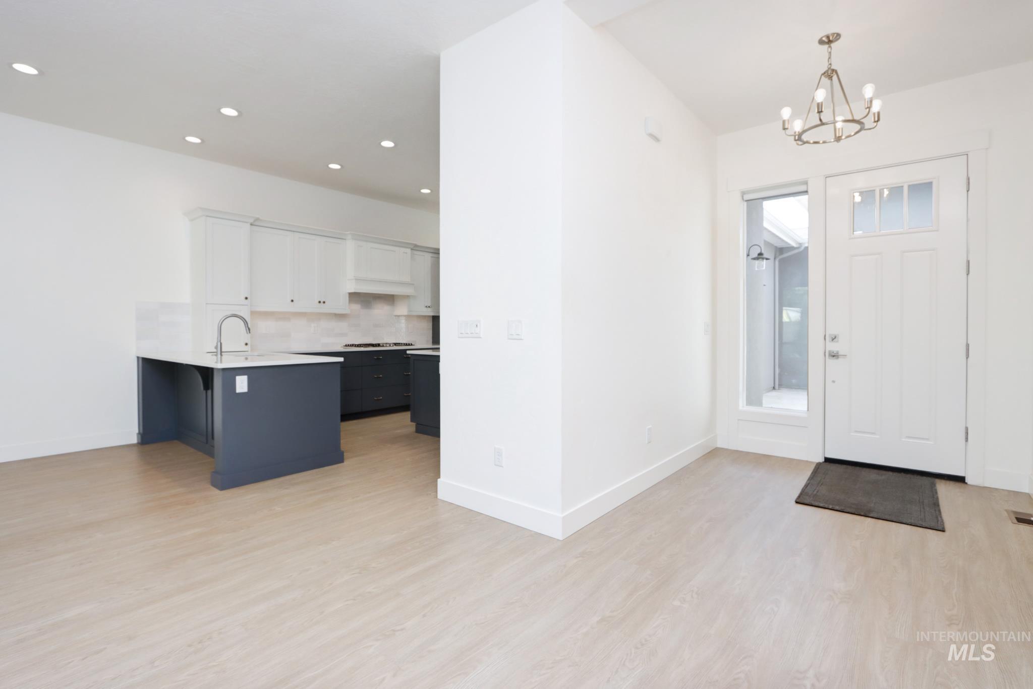 Foyer entrance with light wood-style flooring, a chandelier, and recessed lighting