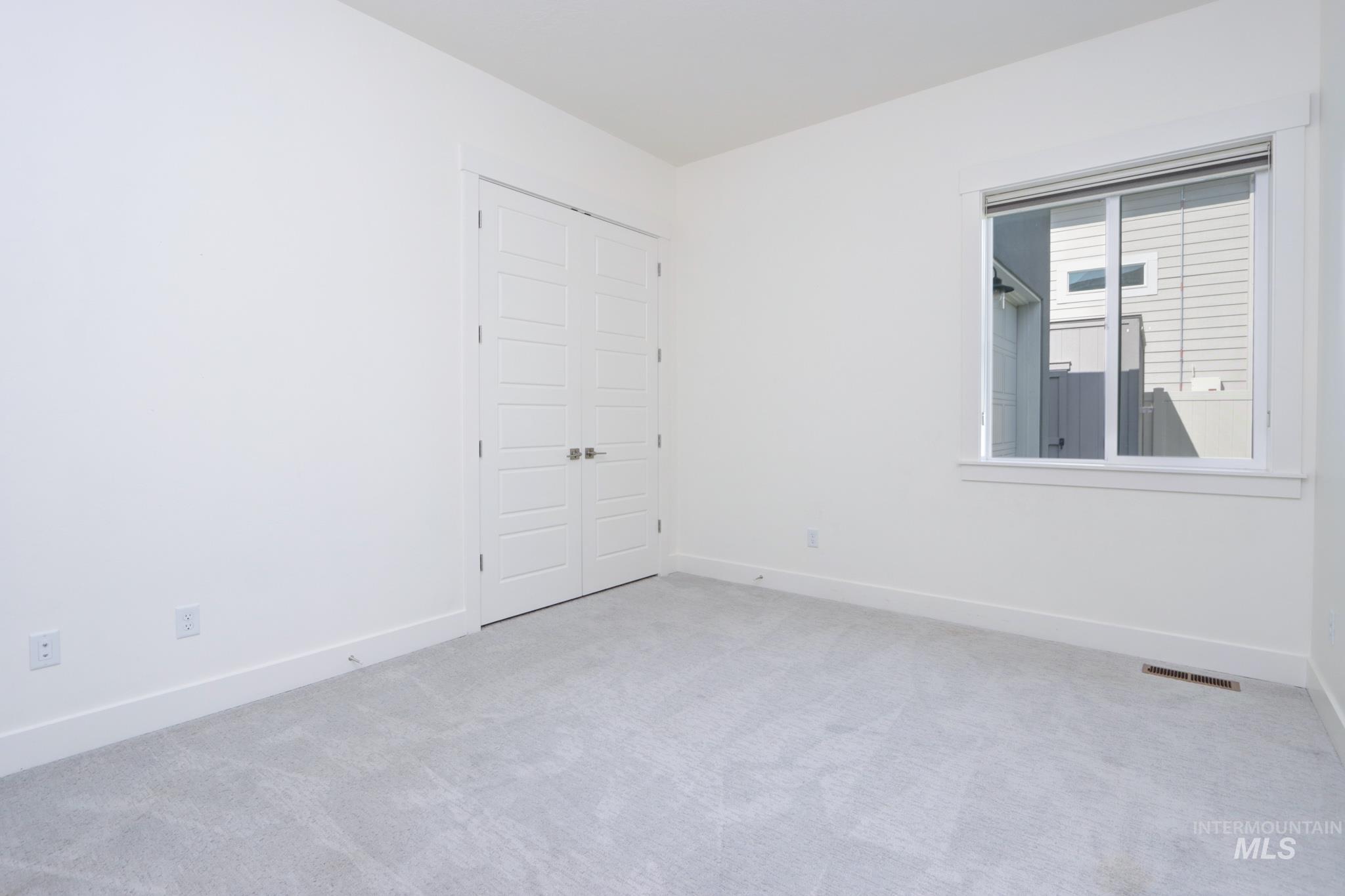 Carpeted empty room with baseboards
