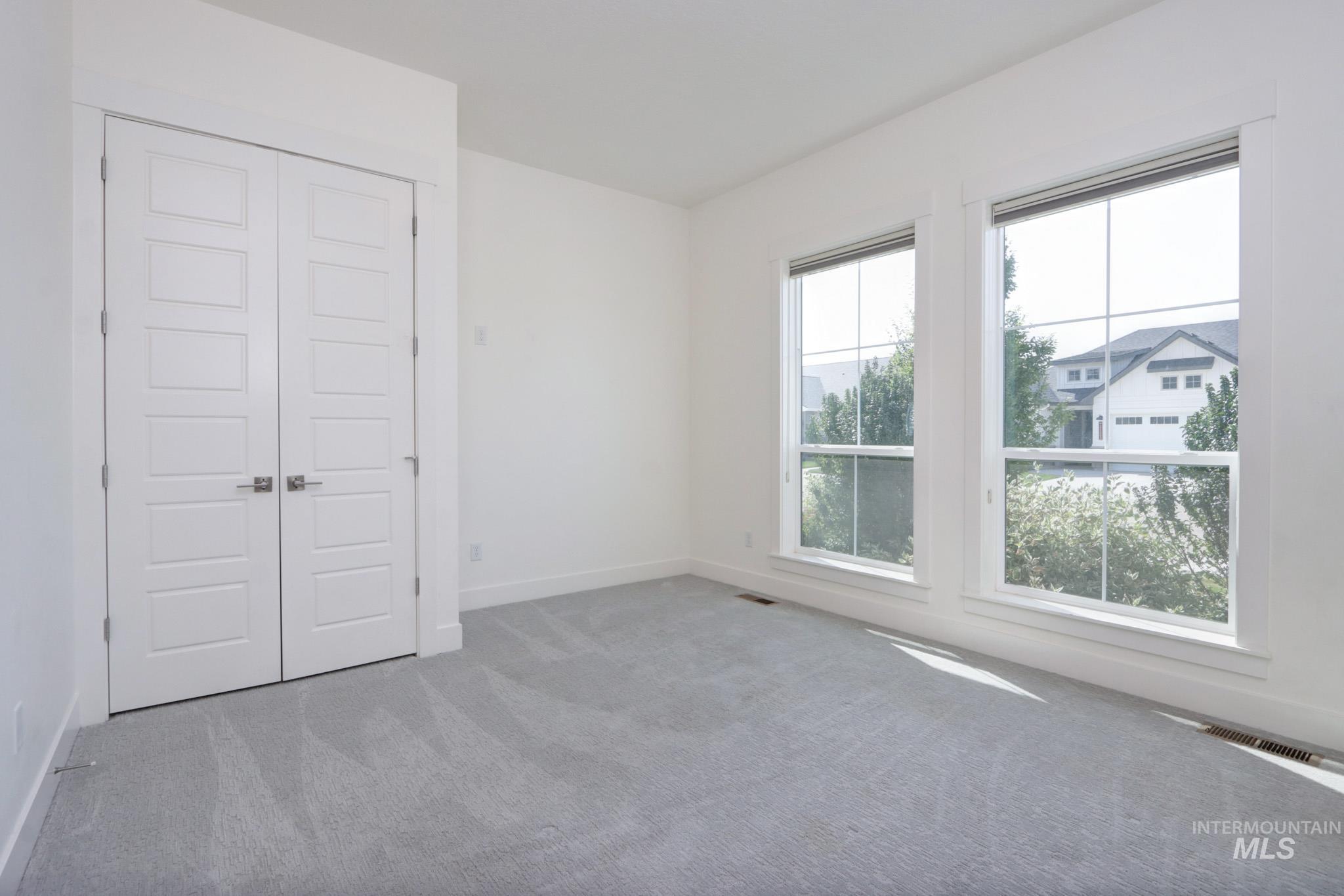Spare room featuring carpet and baseboards