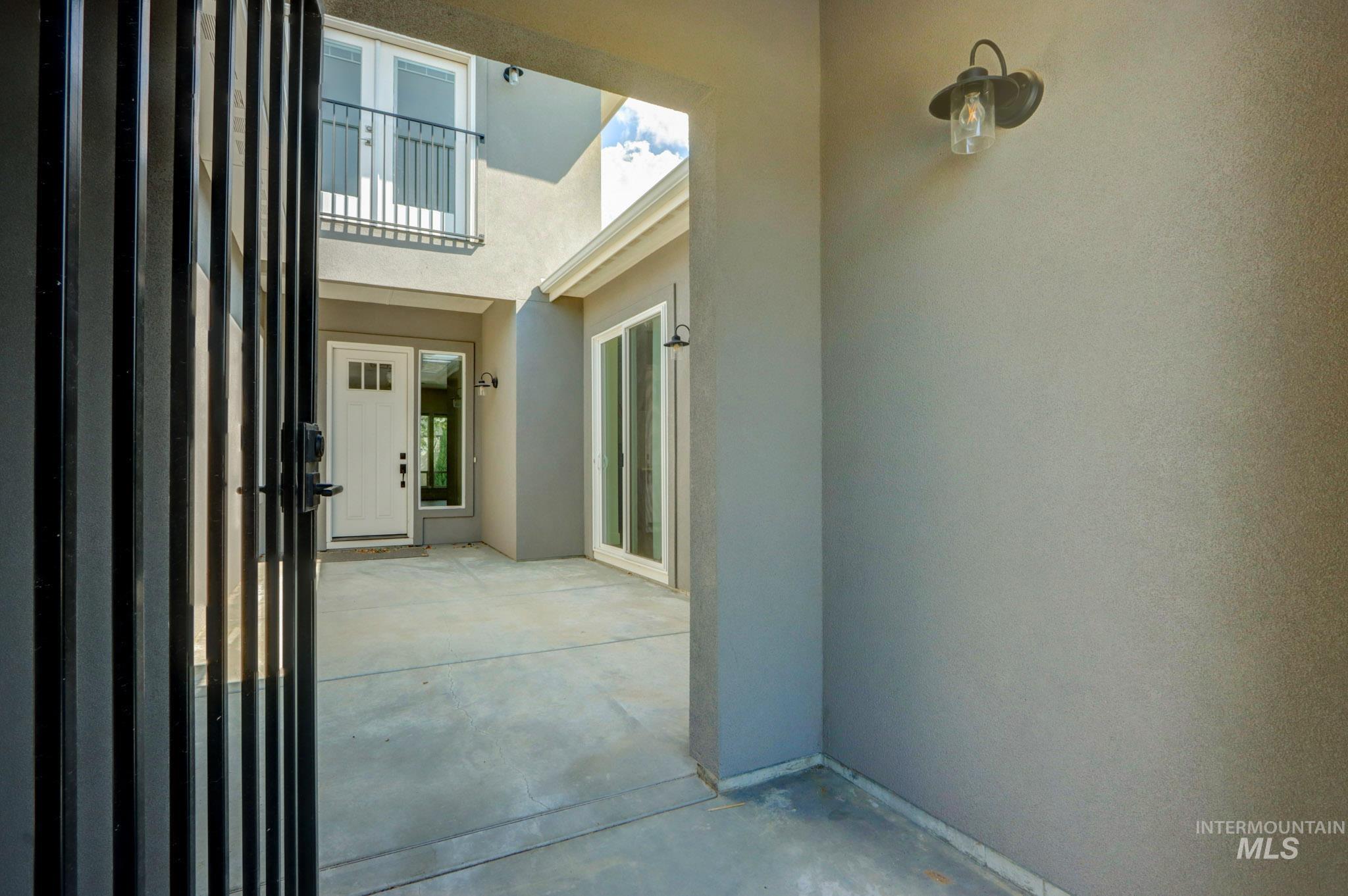 Doorway to property featuring stucco siding and a patio area