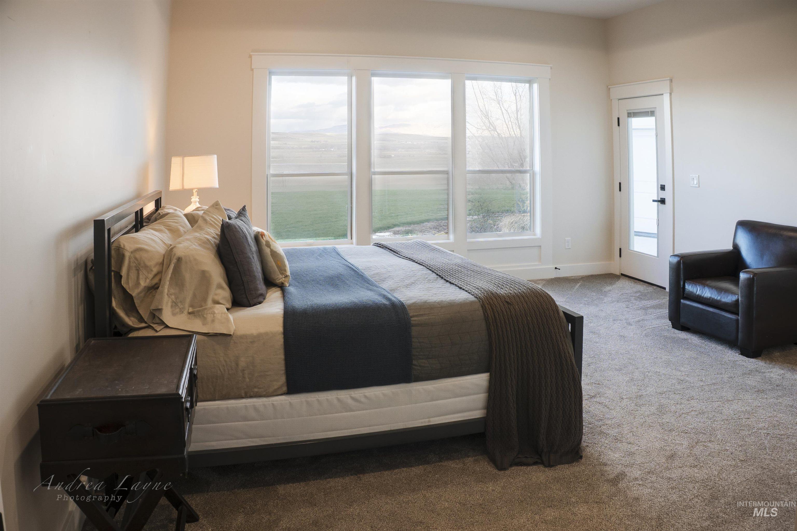 Carpeted bedroom with baseboards and access to exterior