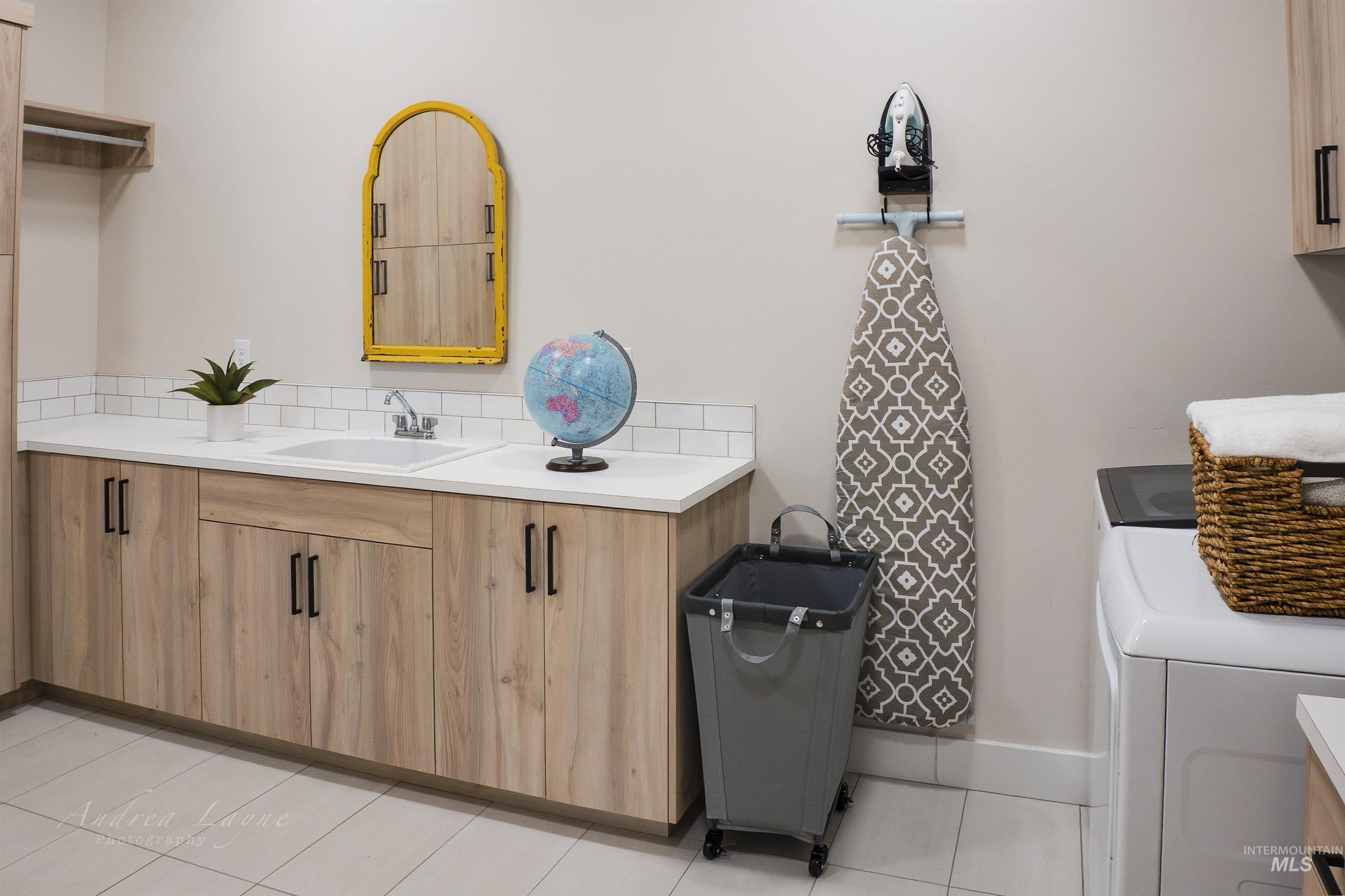 Bathroom featuring vanity, washing machine and clothes dryer, and light tile patterned floors