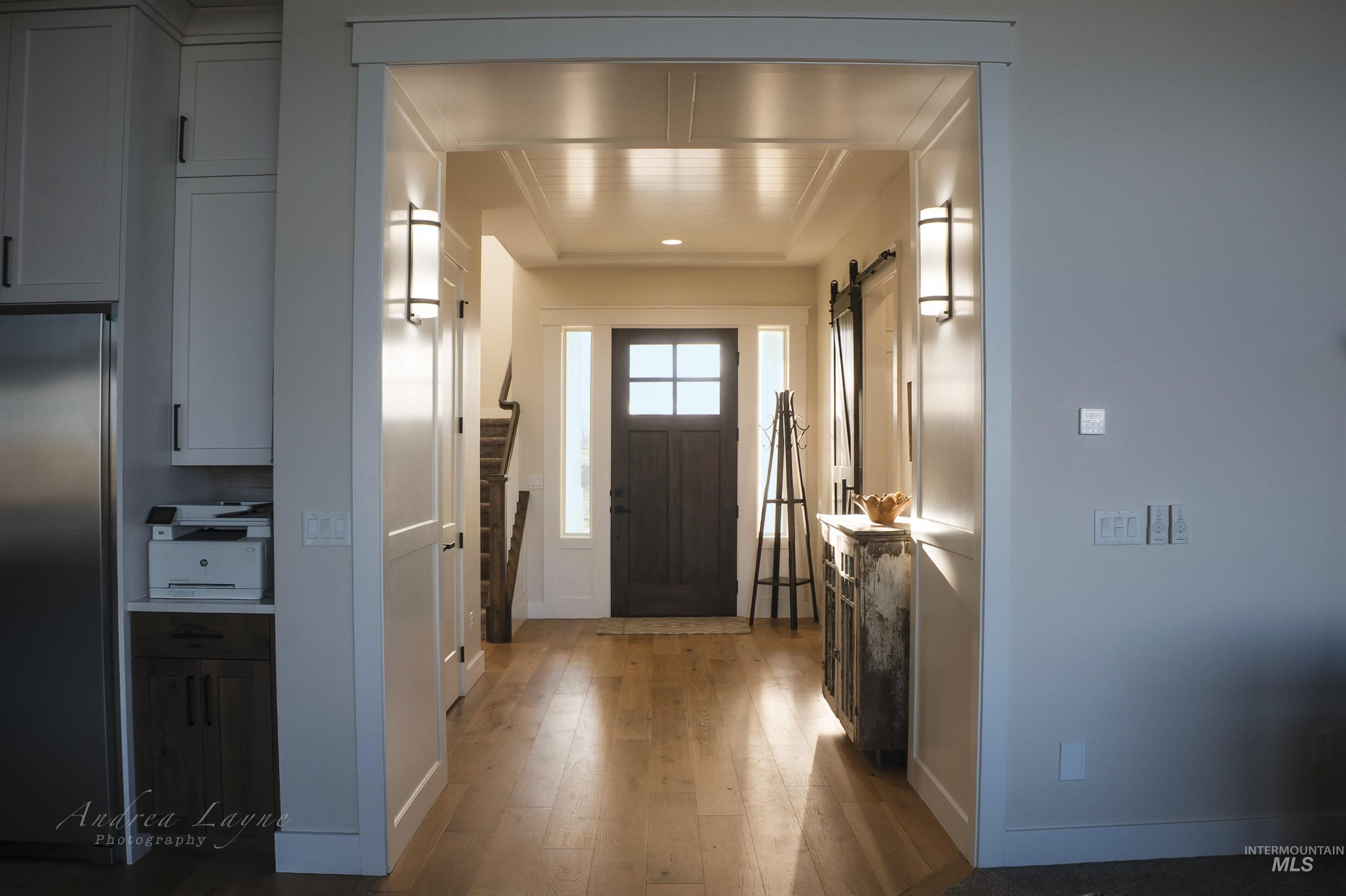 Entrance foyer with light wood-type flooring and a barn door