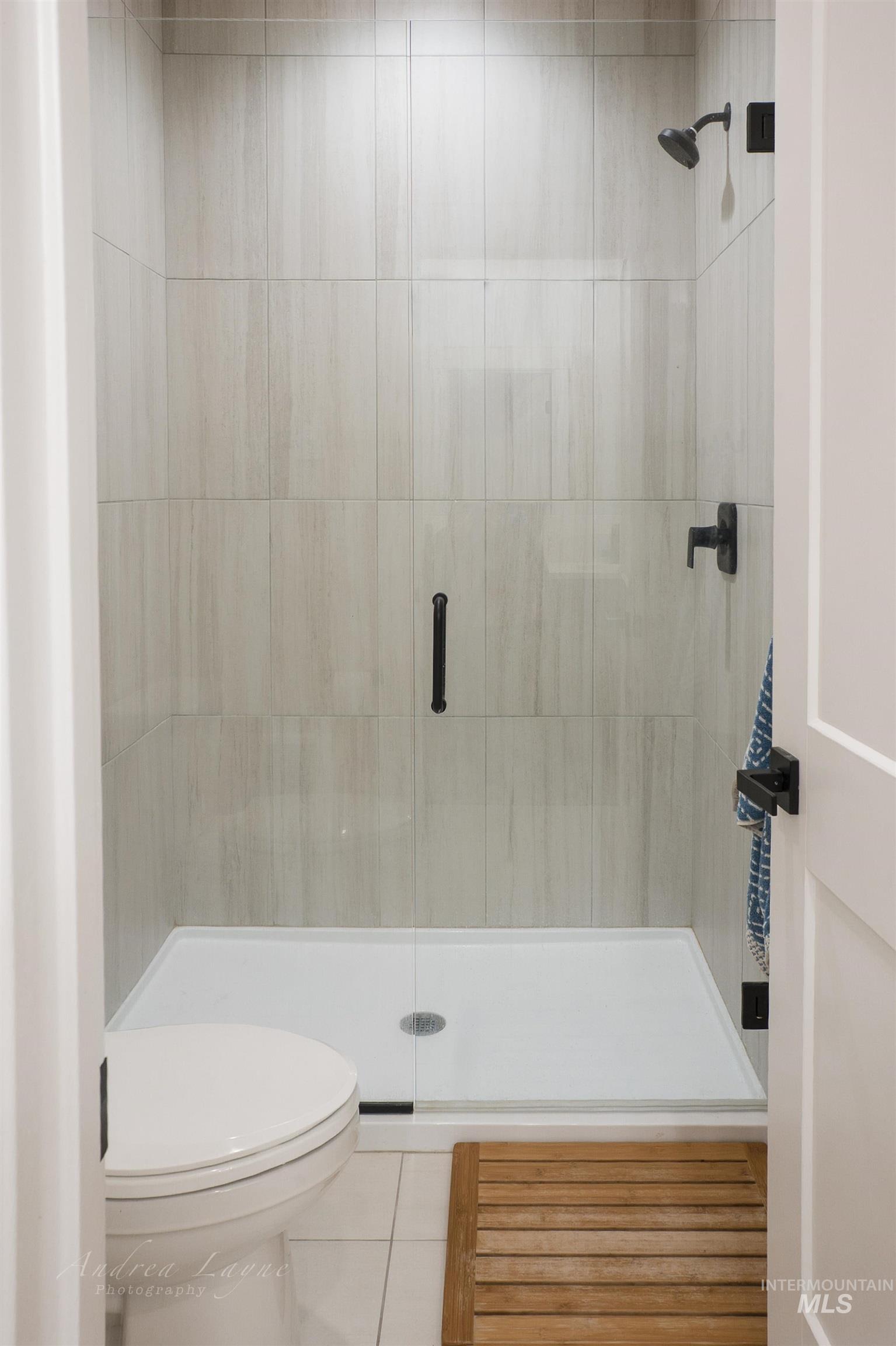 Full bathroom with a stall shower and tile patterned floors