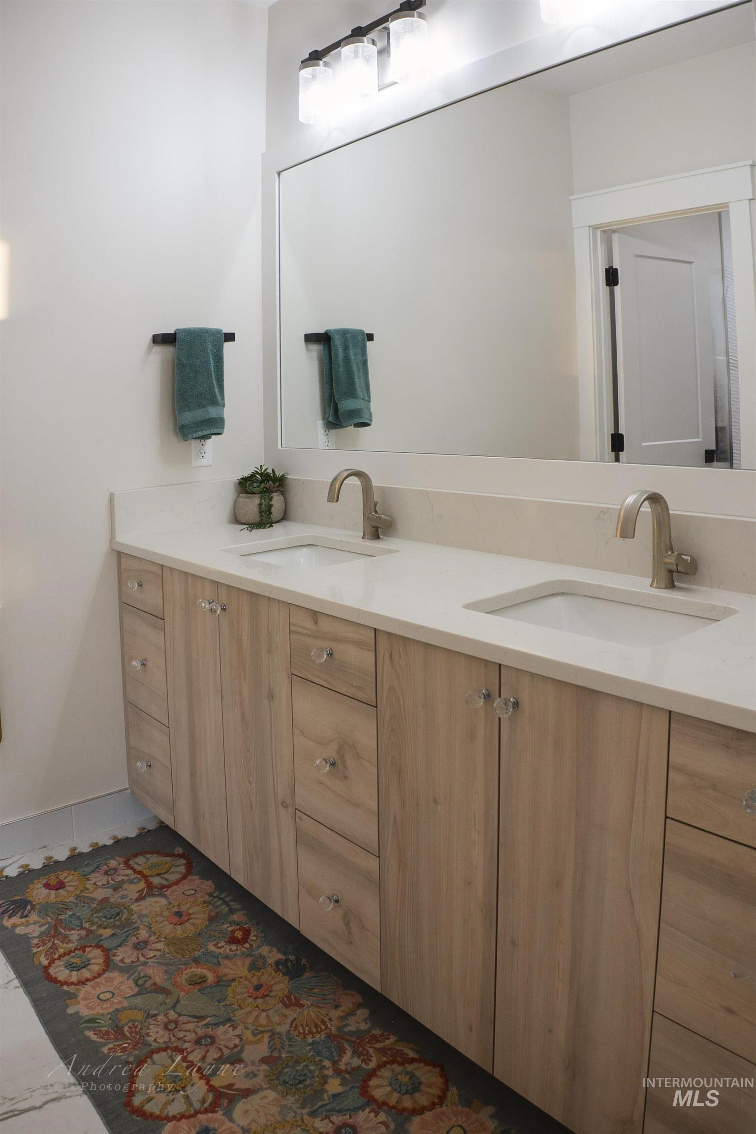 Bathroom with double vanity and dark marble finish flooring