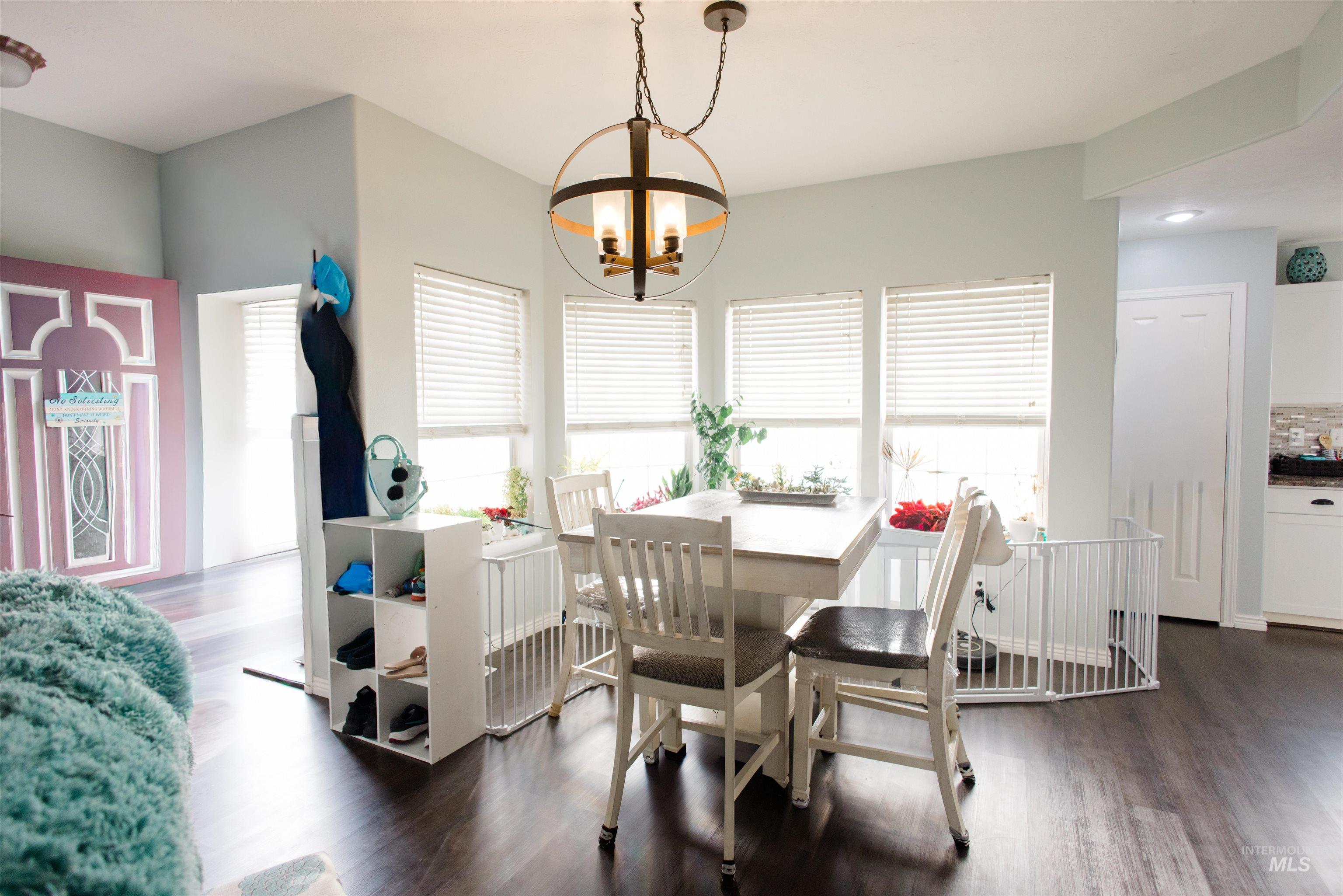 Dining area with dark wood-style flooring and a chandelier