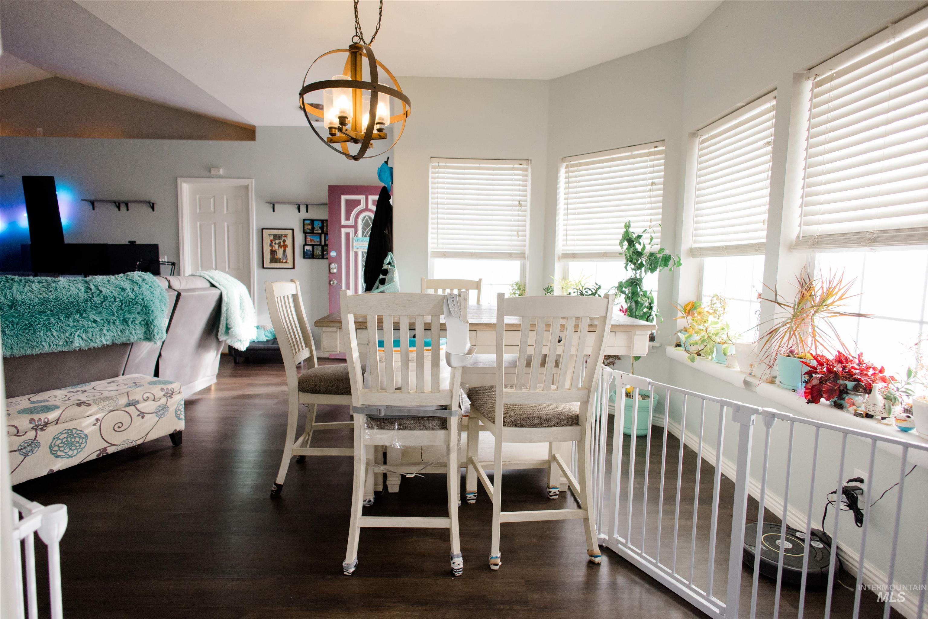Dining room with dark wood-type flooring and a chandelier