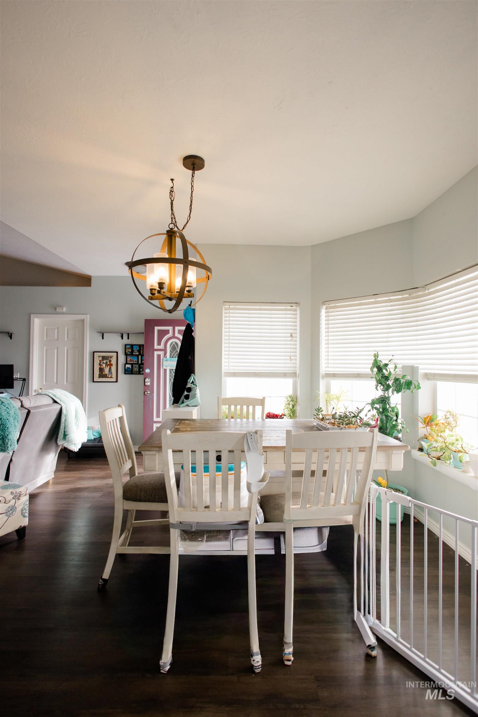 Dining room with dark wood-style floors and a chandelier