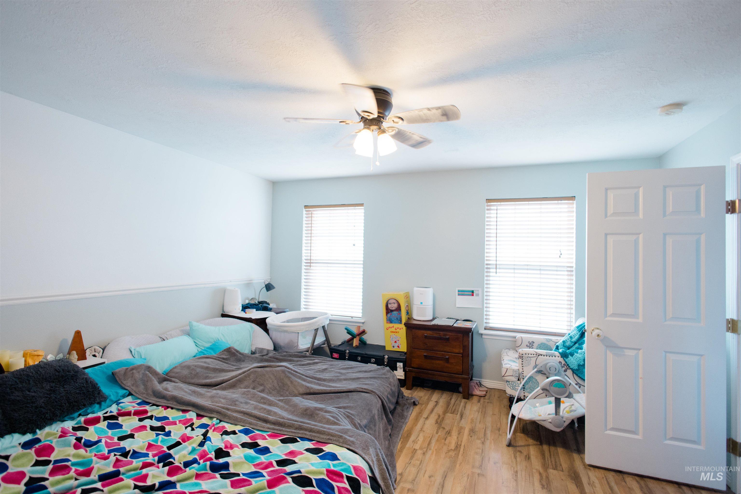Bedroom with light wood-type flooring and a ceiling fan