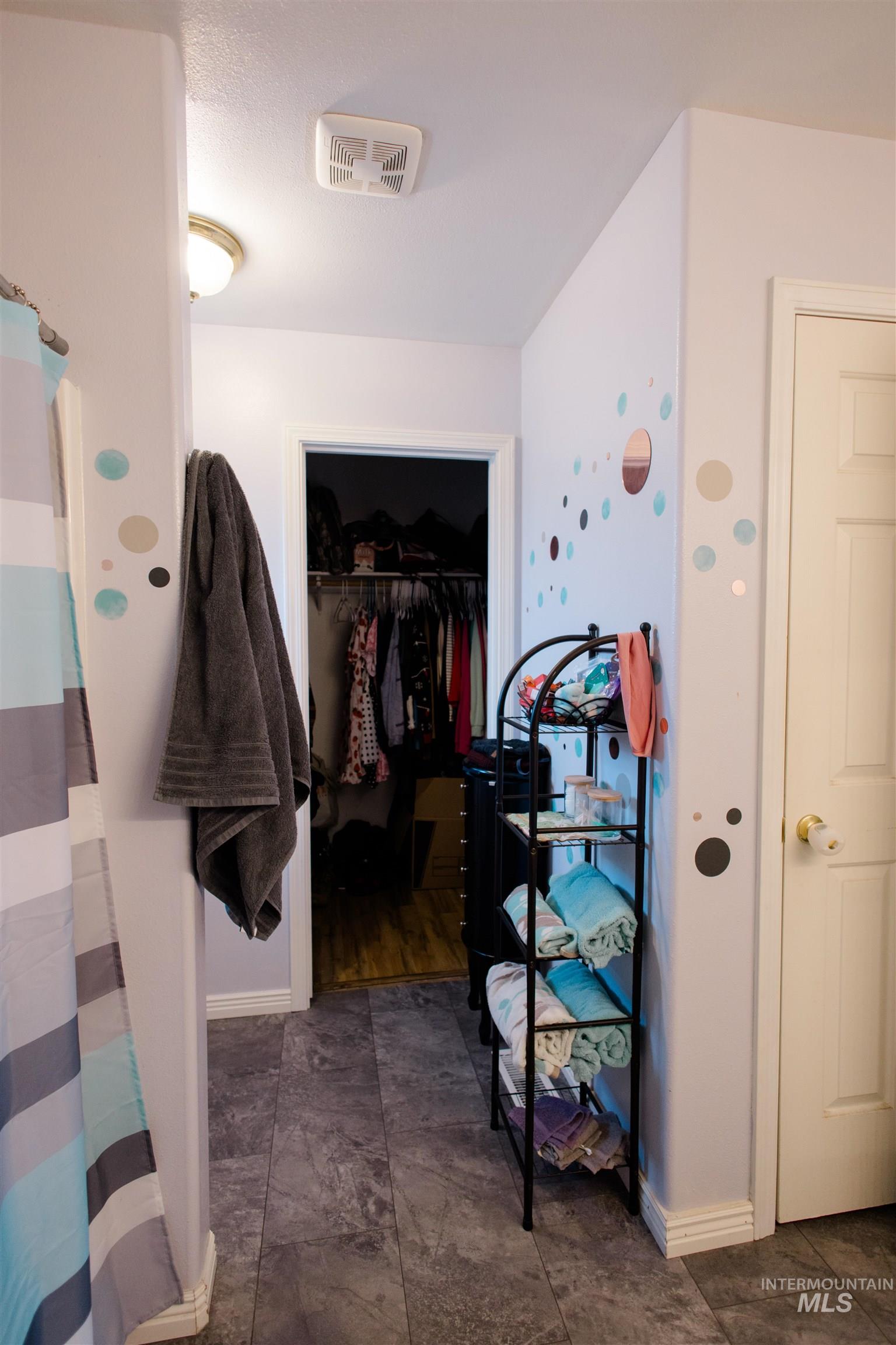 Bathroom featuring a walk in closet and curtained shower