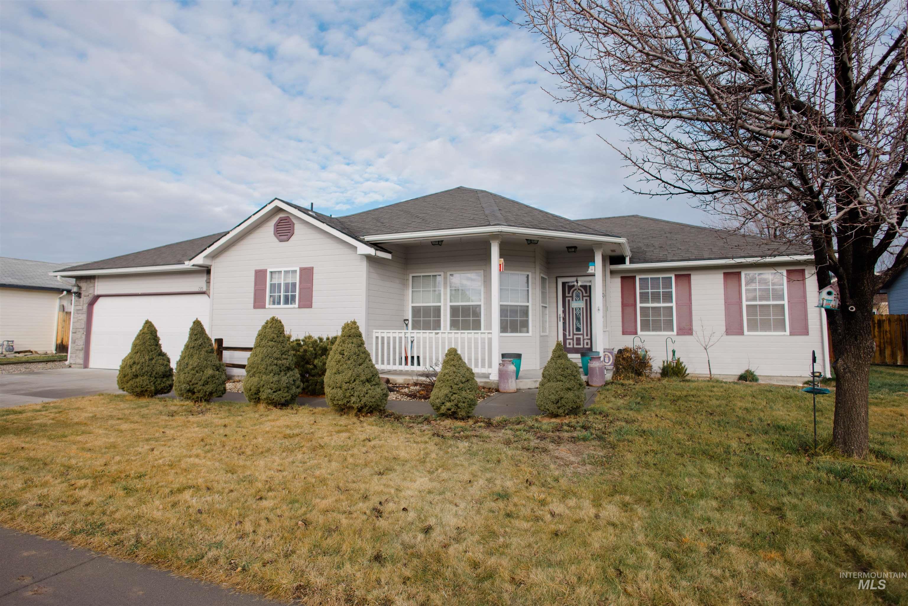 Single story home featuring covered porch, a front lawn, concrete driveway, a shingled roof, and a garage