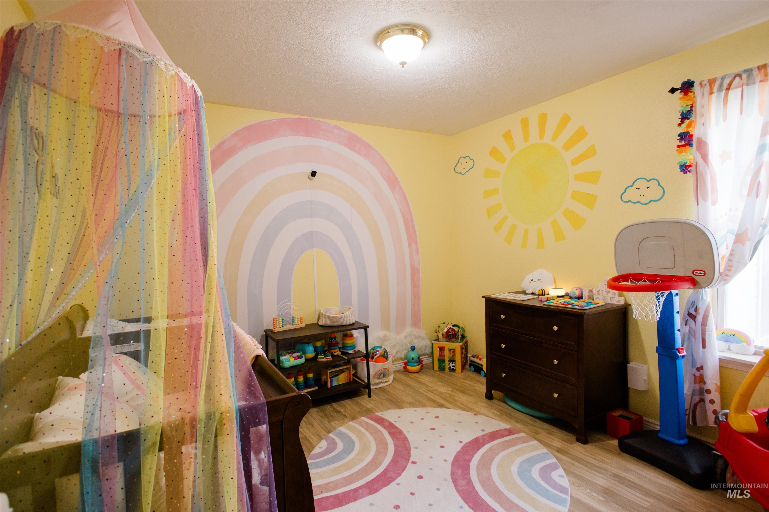 Game room featuring wood finished floors and a textured ceiling