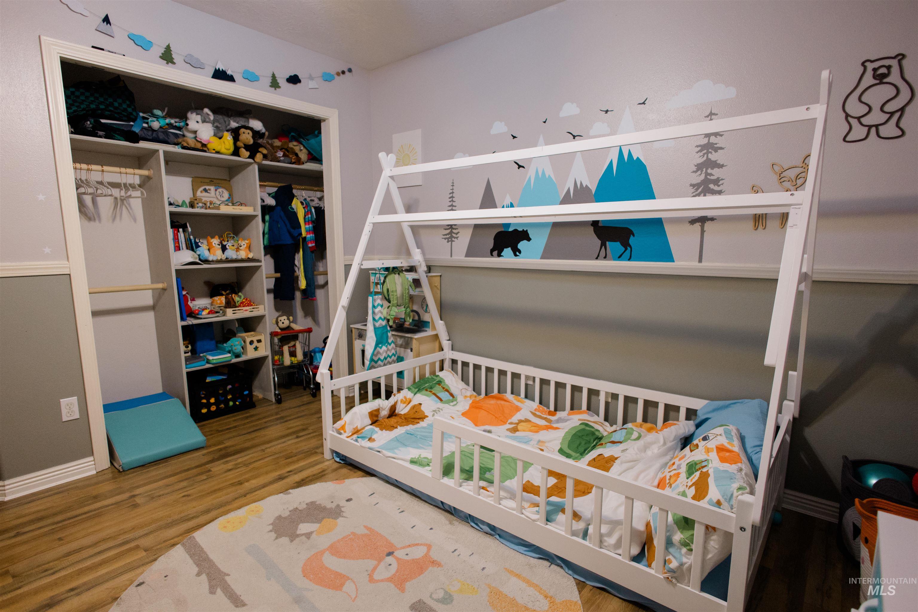 Bedroom featuring wood finished floors and baseboards