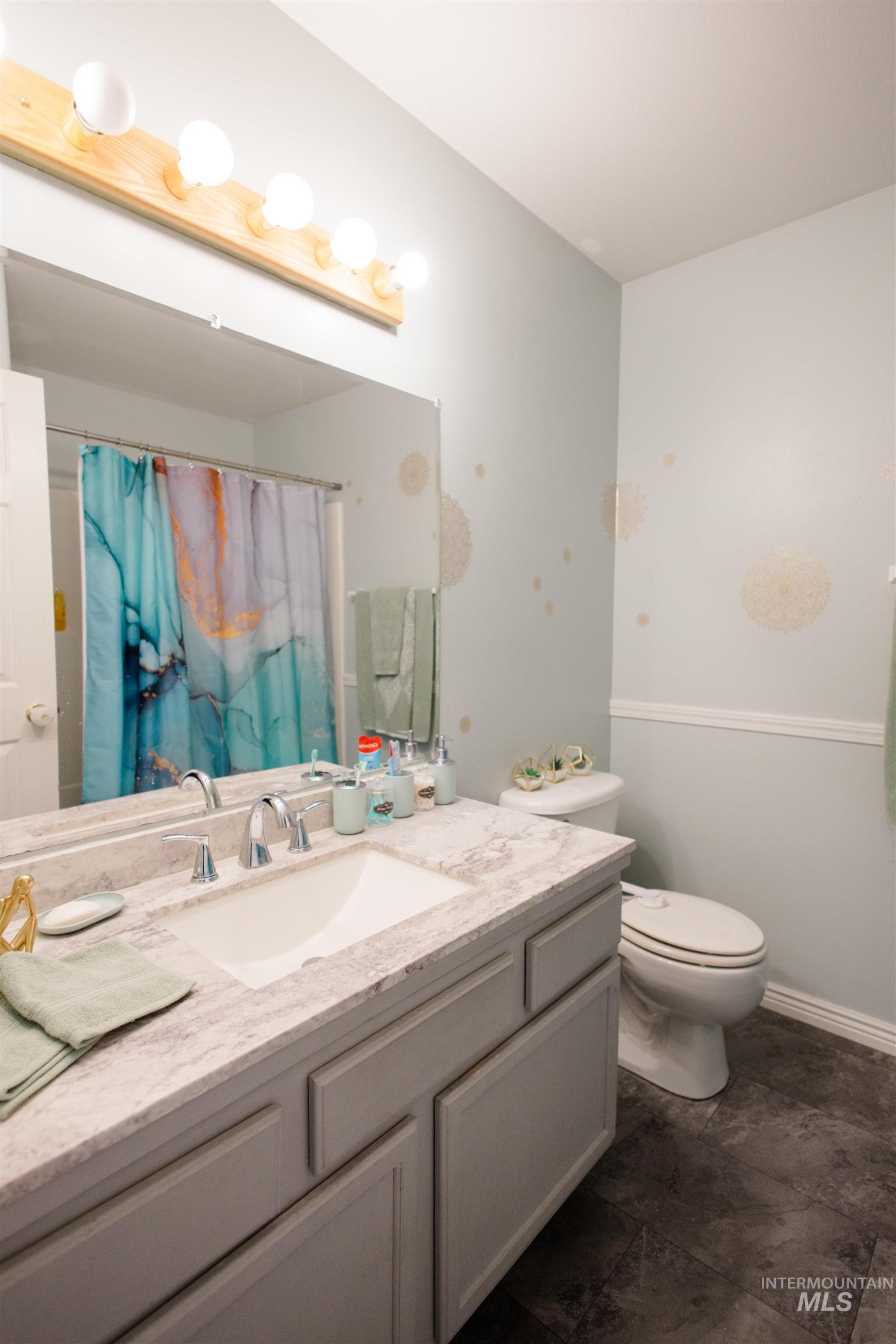Full bath with curtained shower and vanity