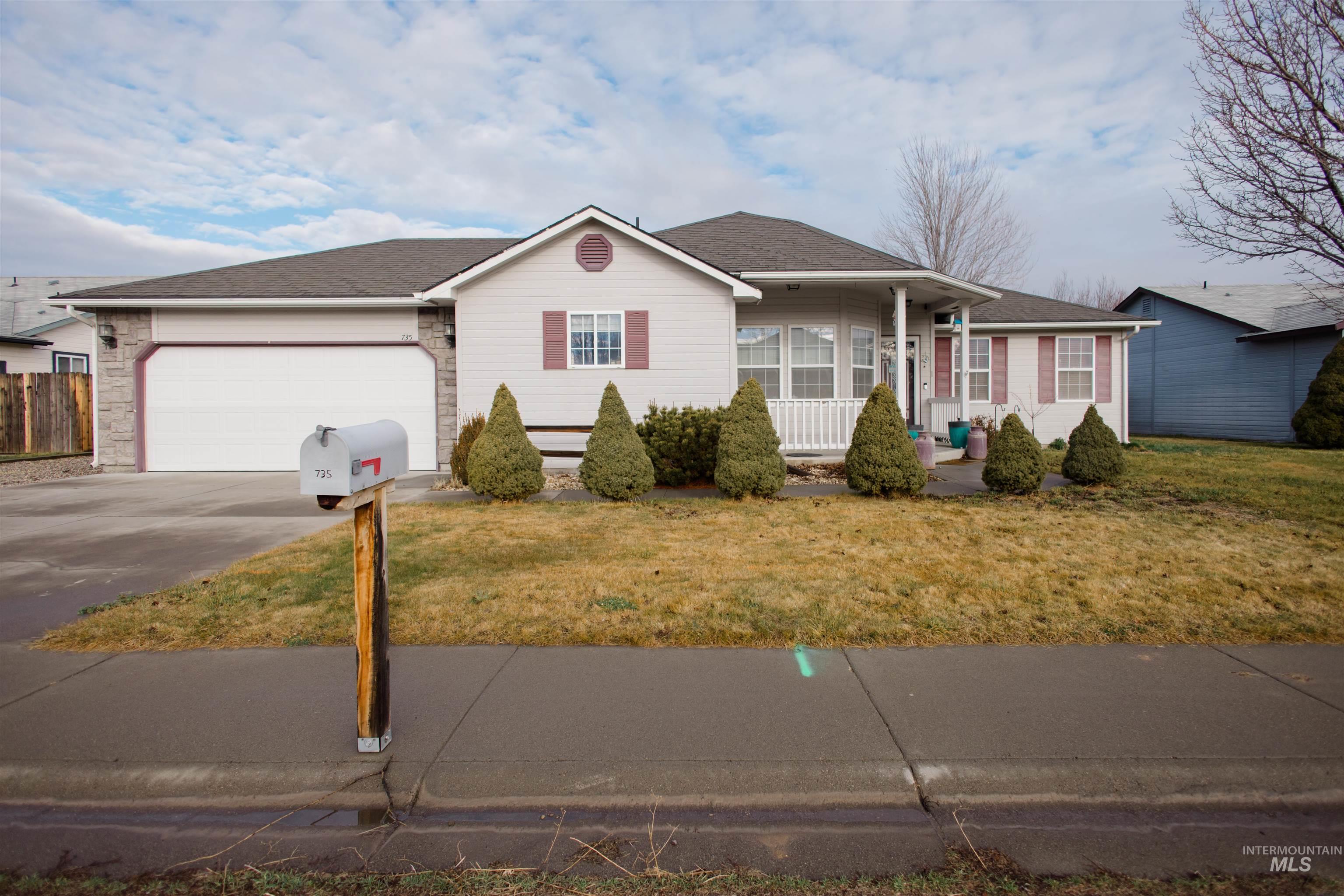 Single story home with covered porch, concrete driveway, a front lawn, a shingled roof, and an attached garage