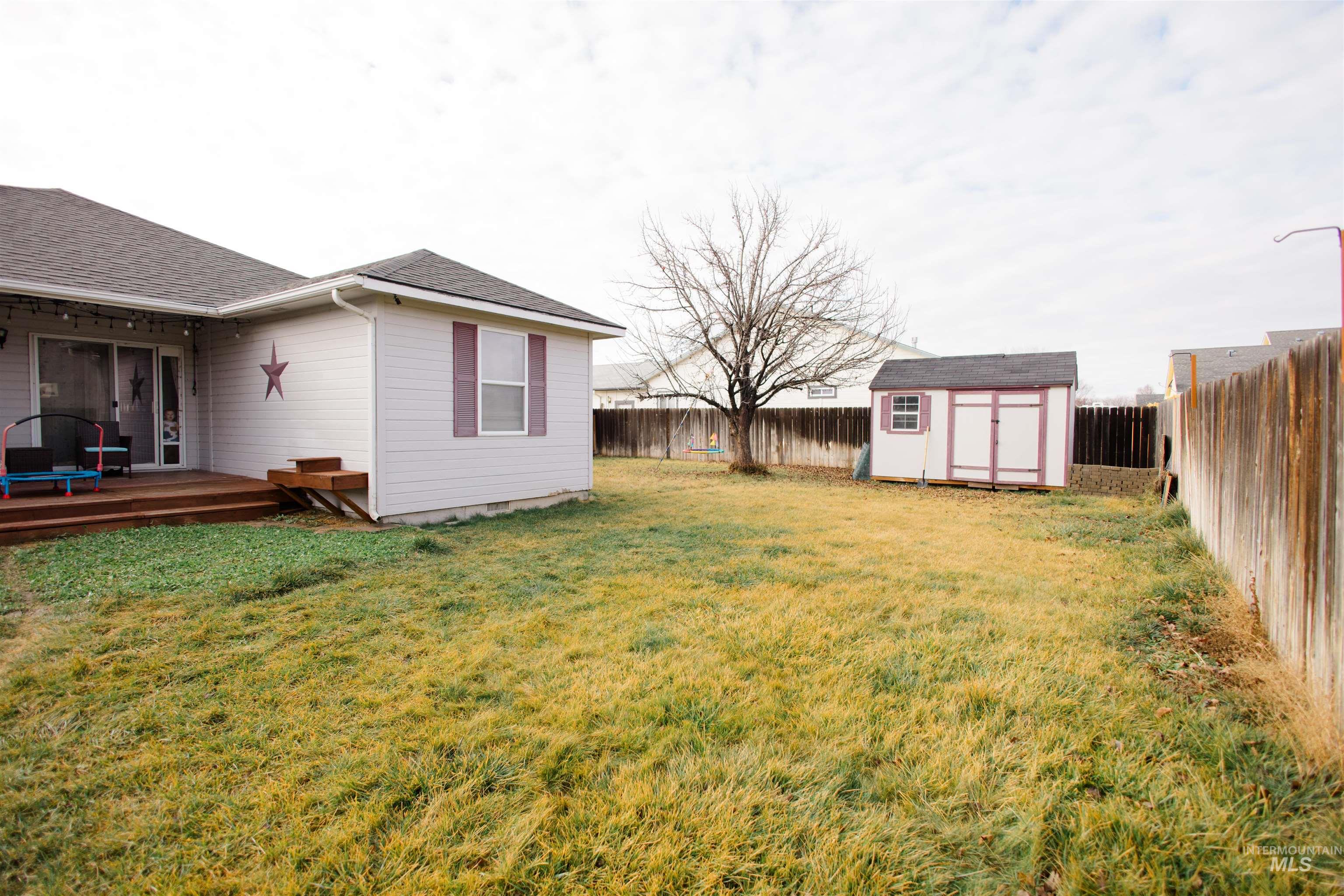 Fenced backyard with a shed and a deck