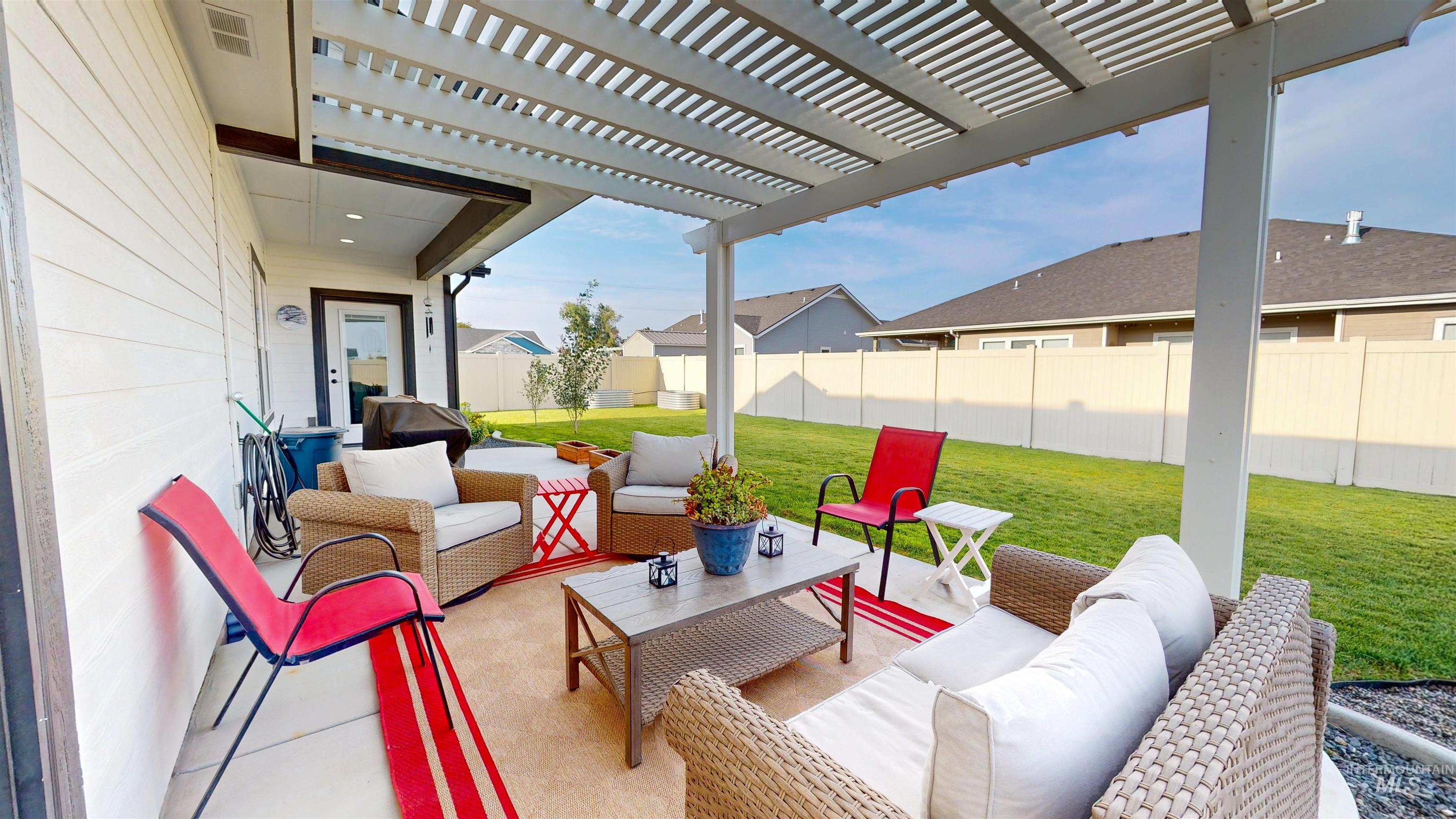 Fenced backyard with an outdoor hangout area, a pergola, a patio, and area for grilling