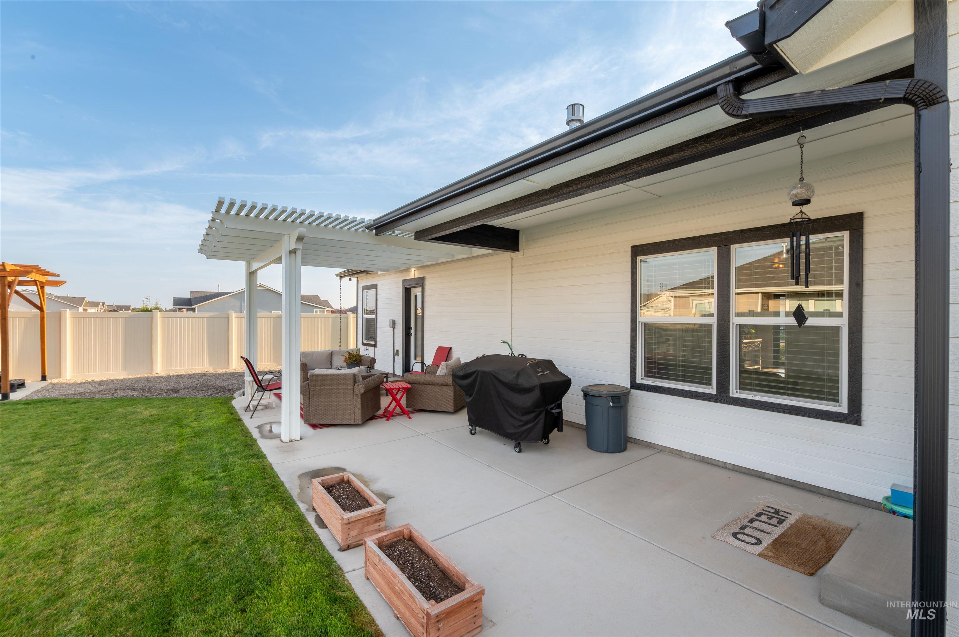 View of patio with a grill, an outdoor living space, a garden, and a pergola