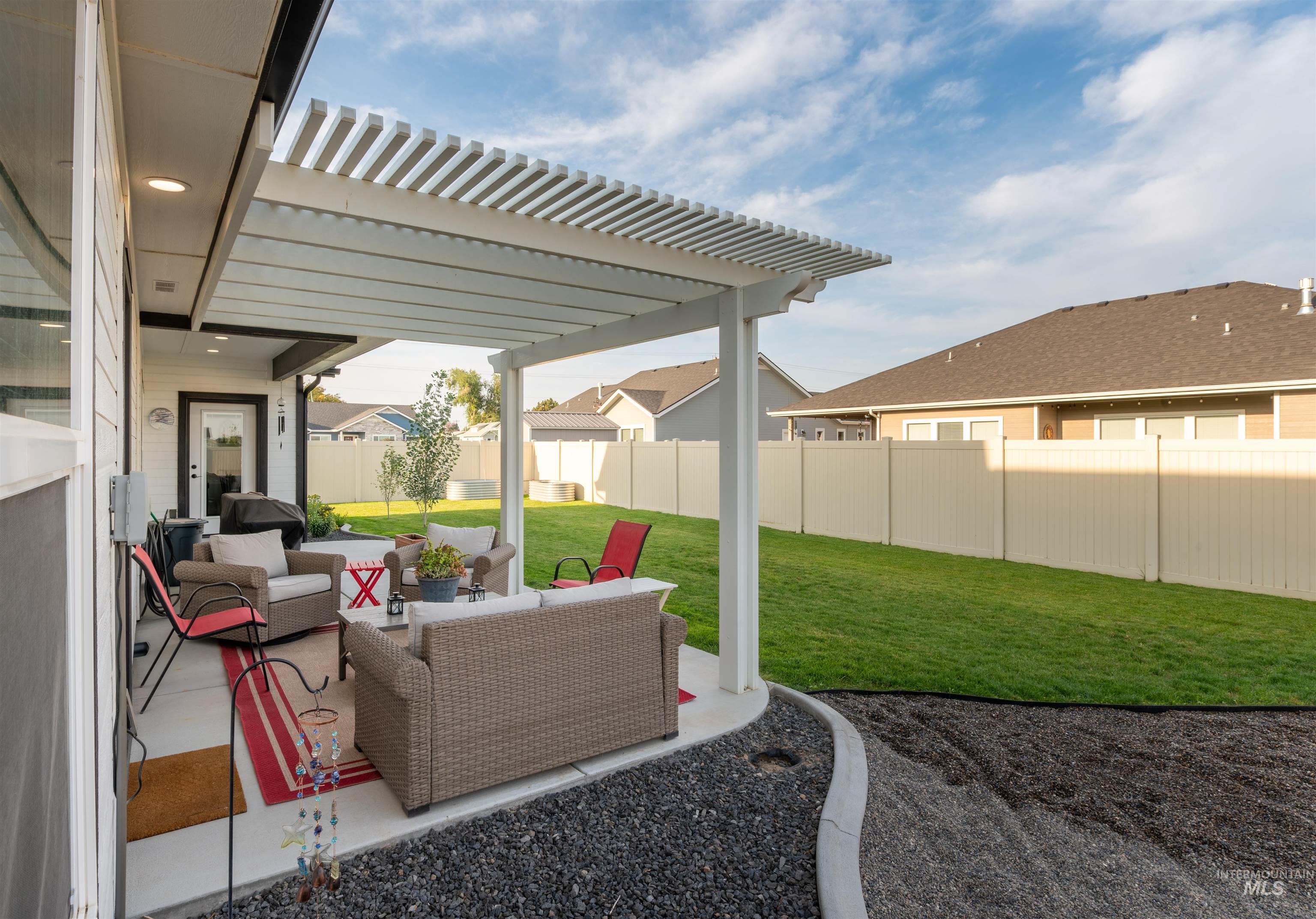 Fenced backyard with a pergola, a patio area, and outdoor lounge area