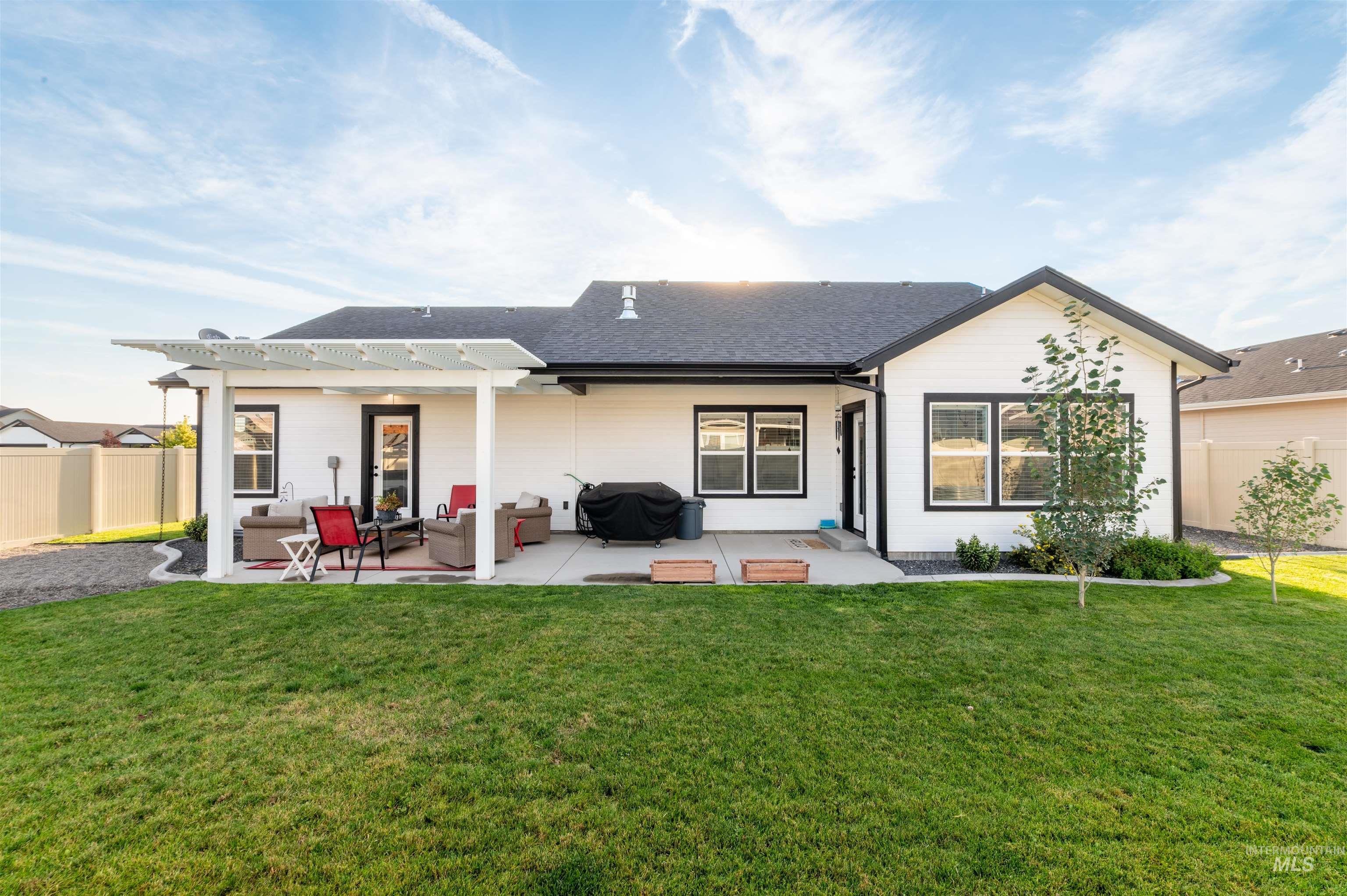 Back of house featuring a patio area and a shingled roof