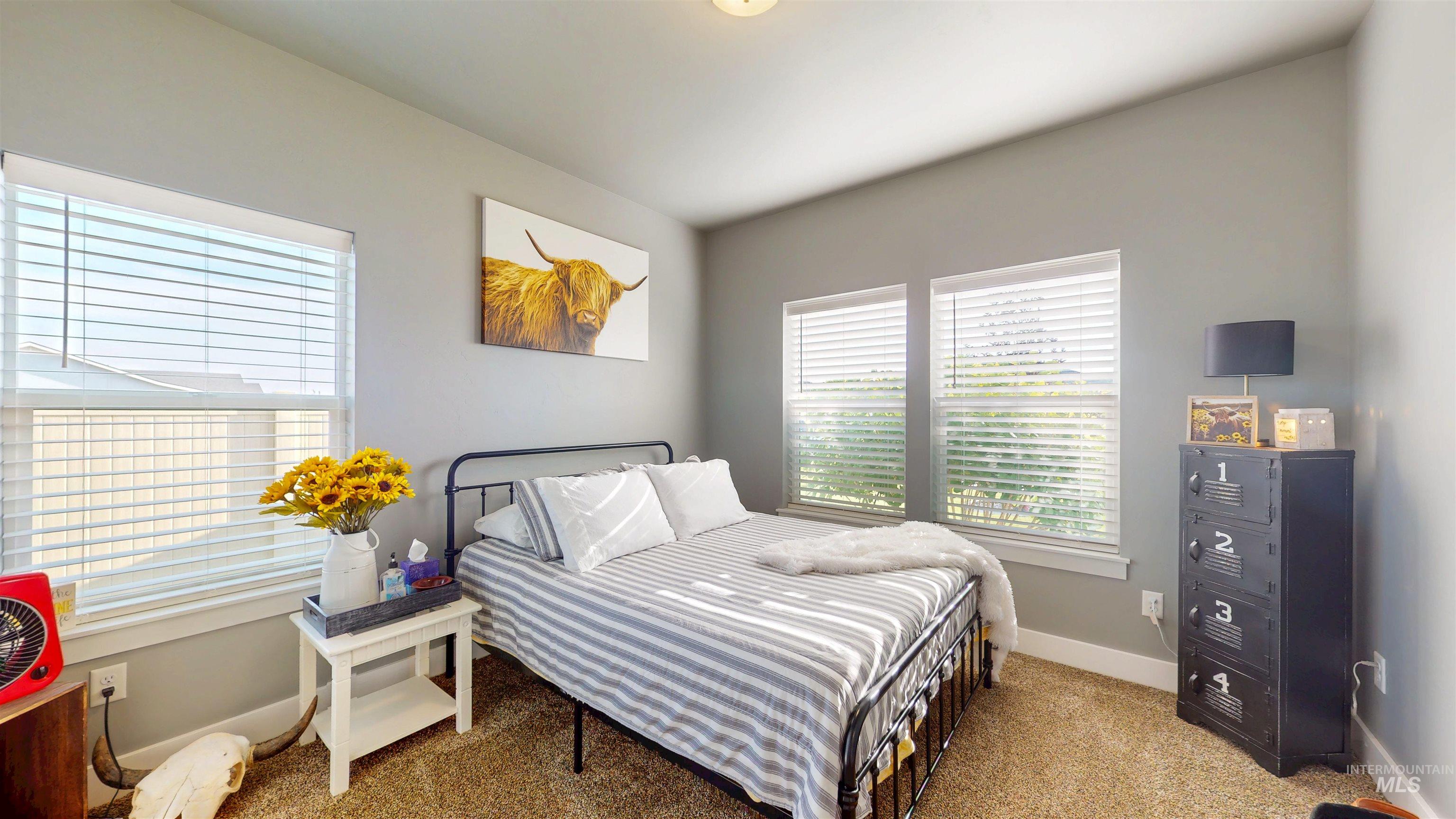 Bedroom featuring carpet and multiple windows