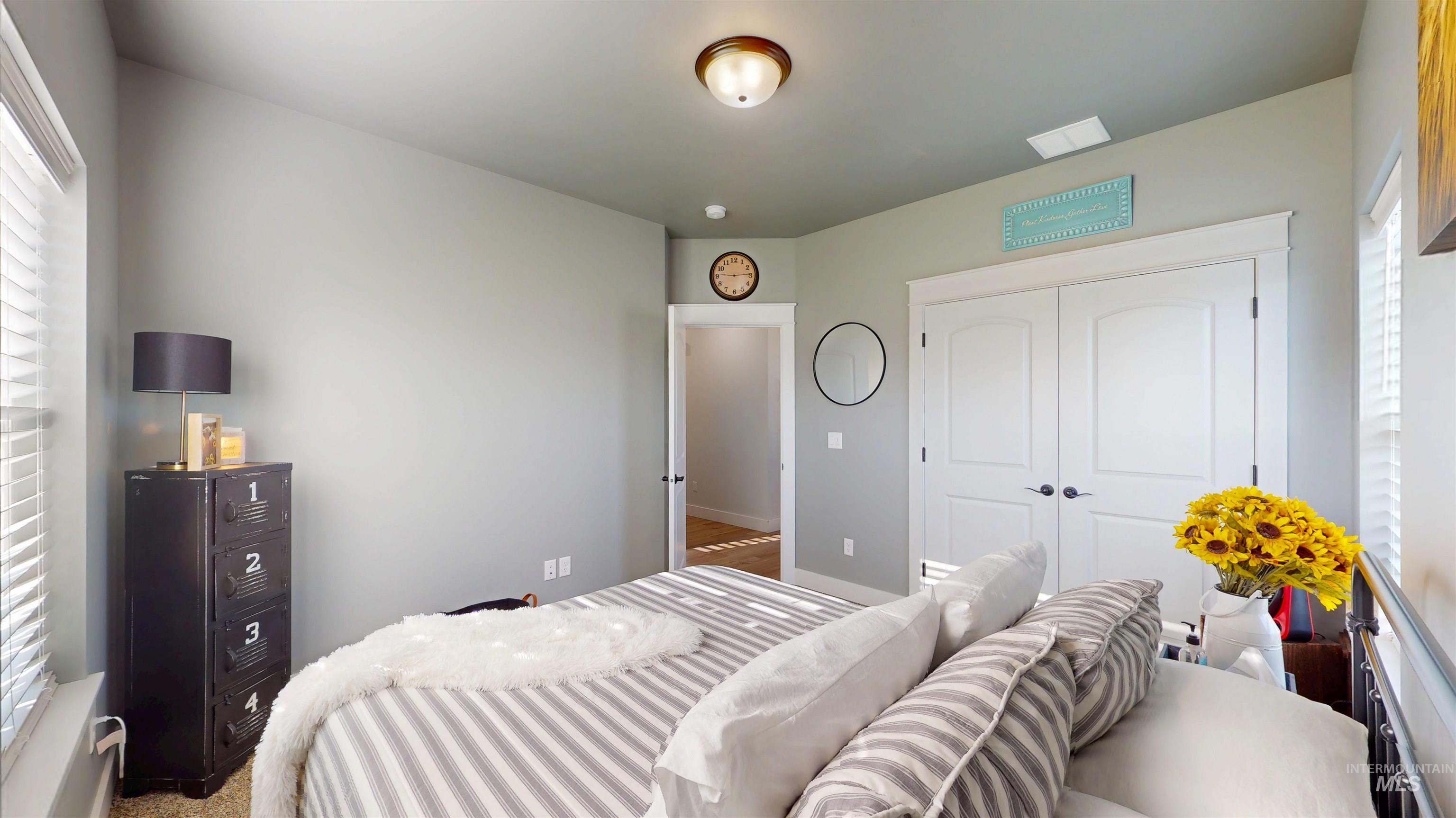 Bedroom featuring multiple windows and a closet