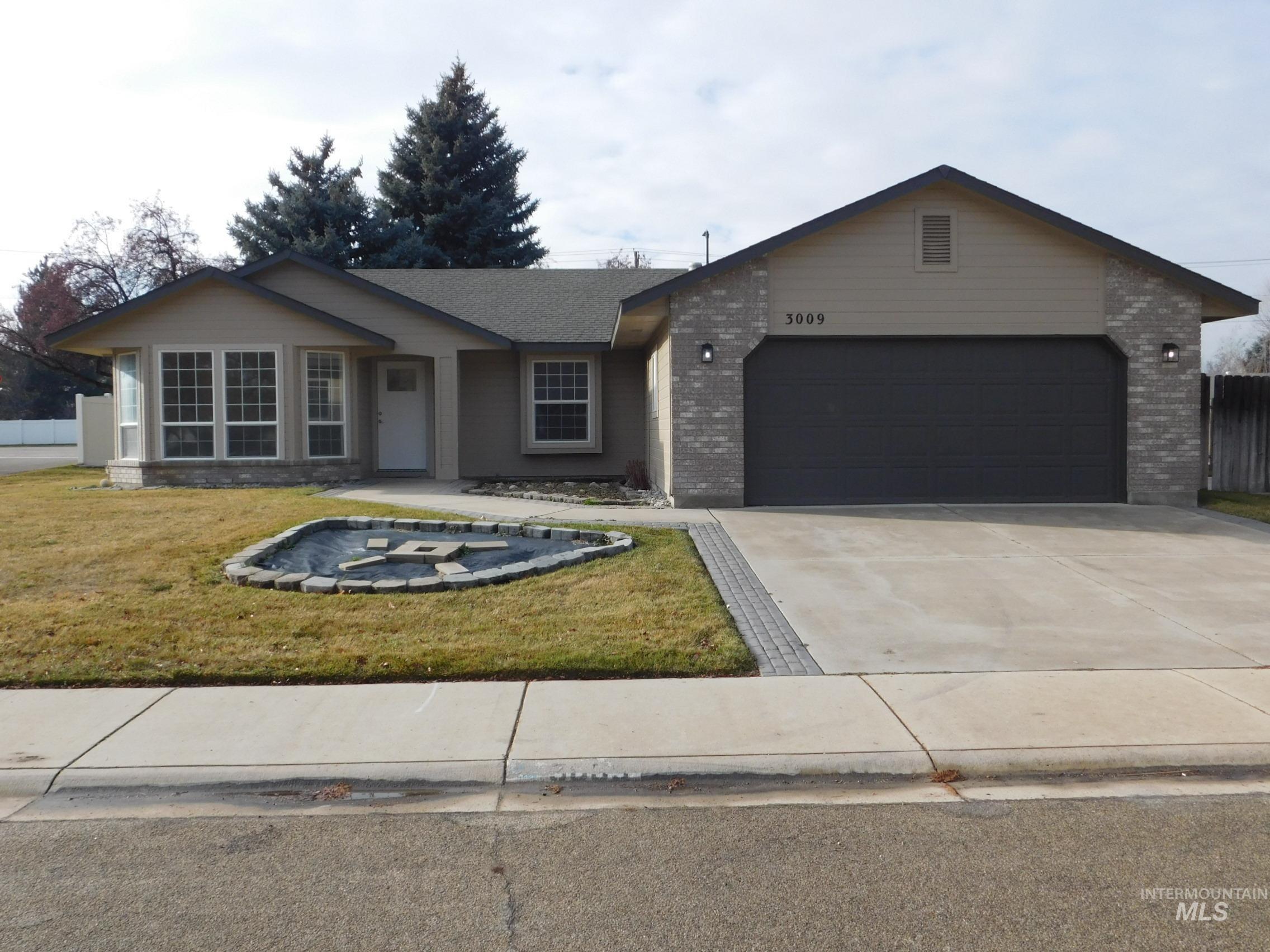 Ranch-style house with brick siding, driveway, a front yard, and a garage