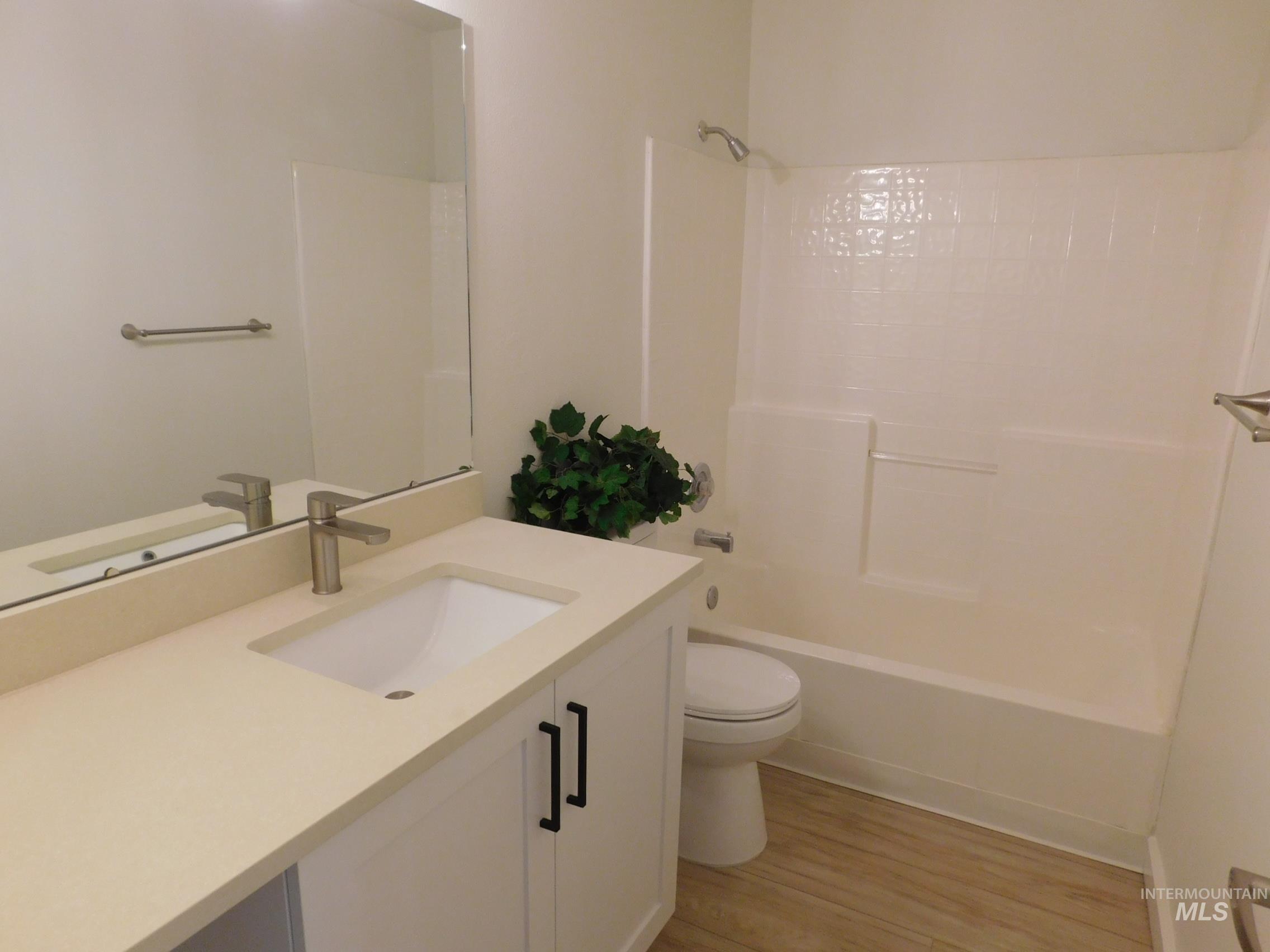 Full bathroom with vanity, shower / washtub combination, and light wood-type flooring