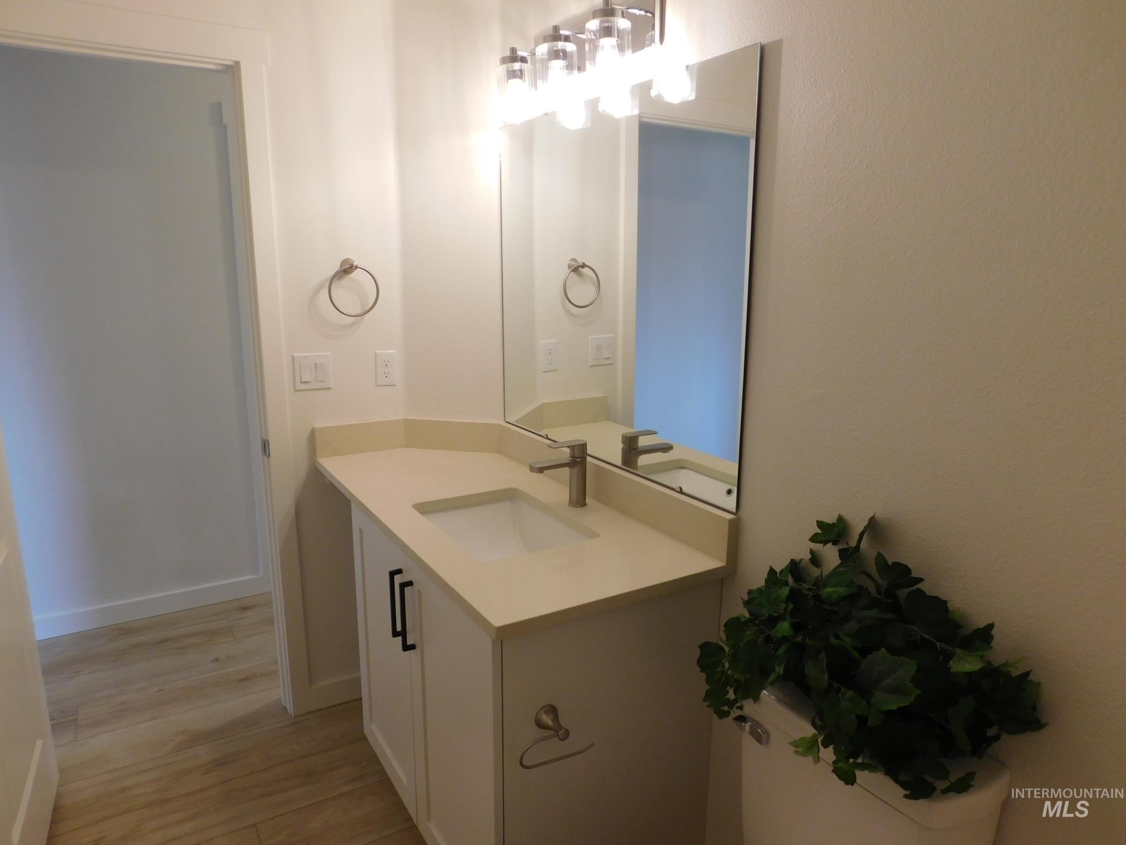 Half bathroom featuring vanity and light wood-style flooring