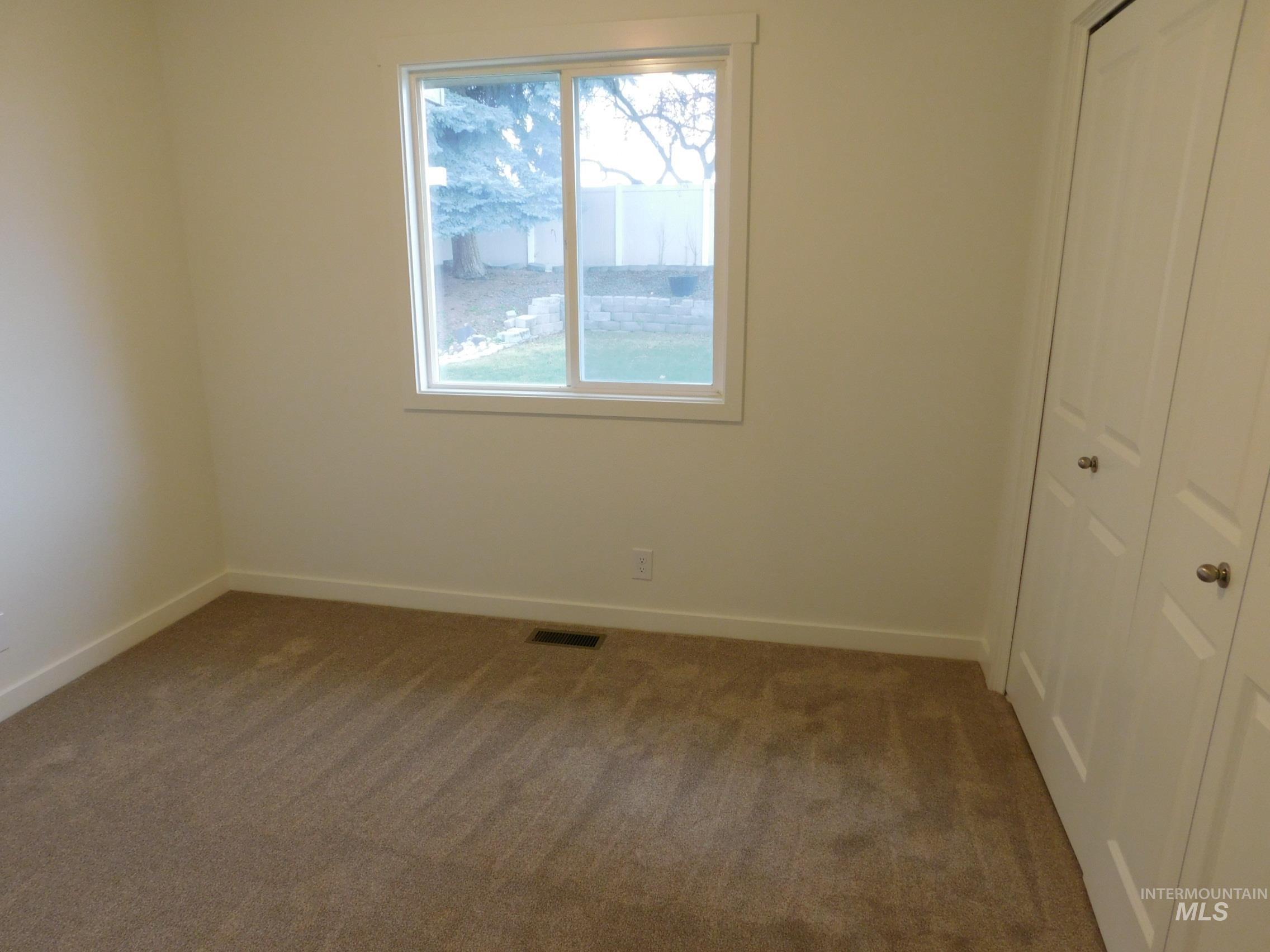 Unfurnished bedroom with dark colored carpet and a closet