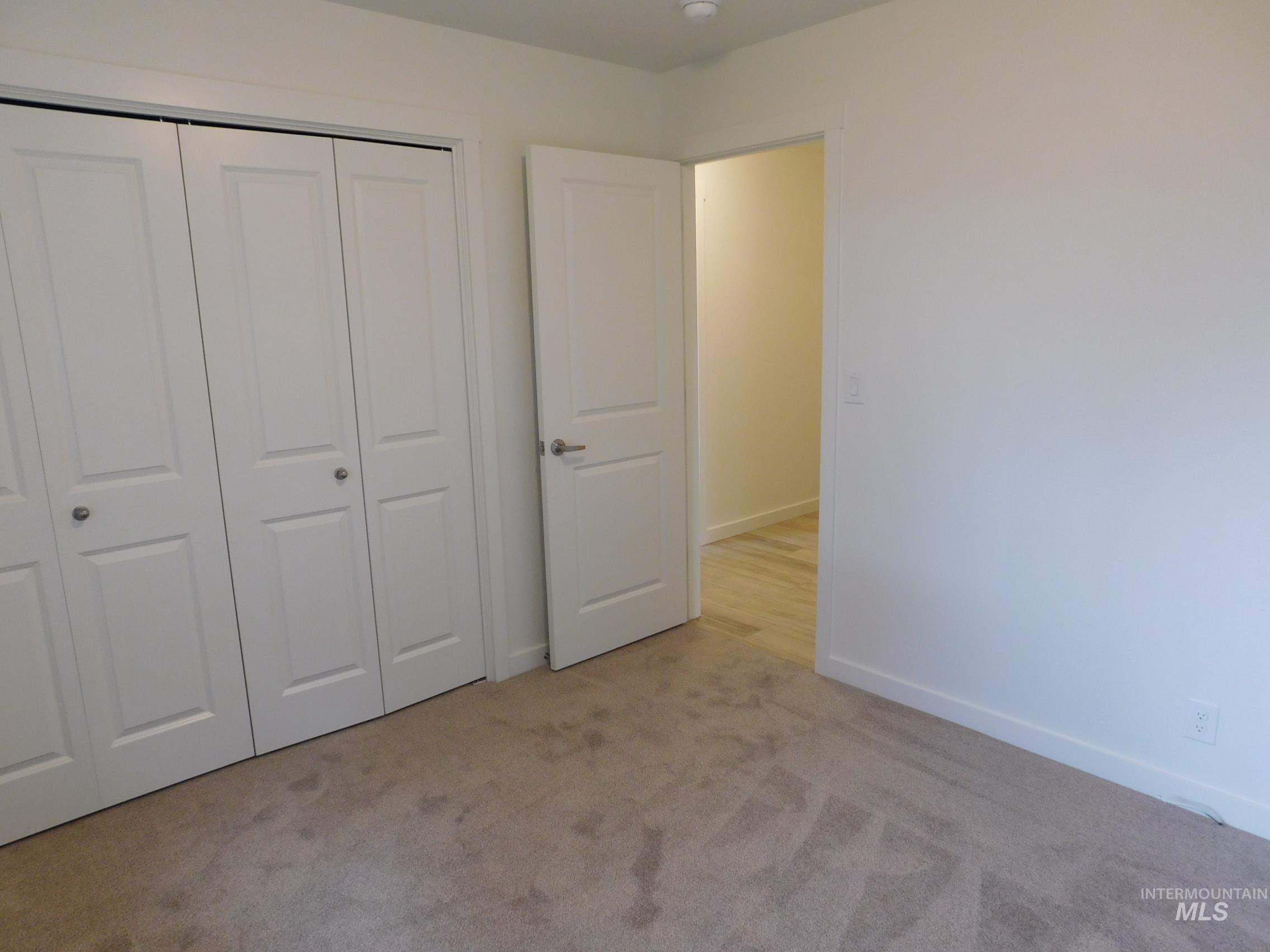 Unfurnished bedroom with a closet and light colored carpet
