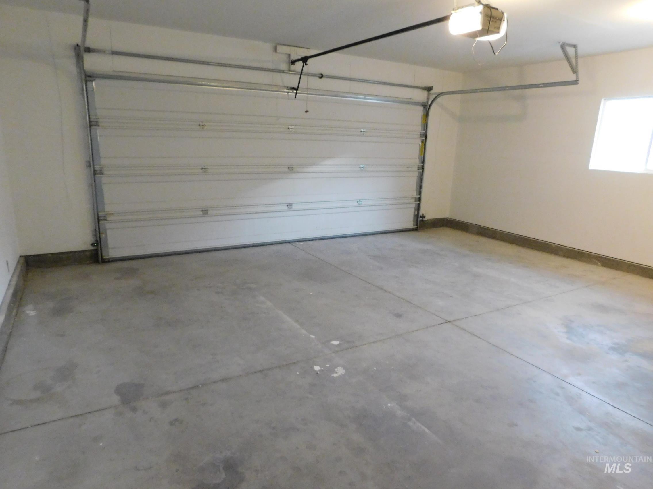 Garage with baseboards and a garage door opener