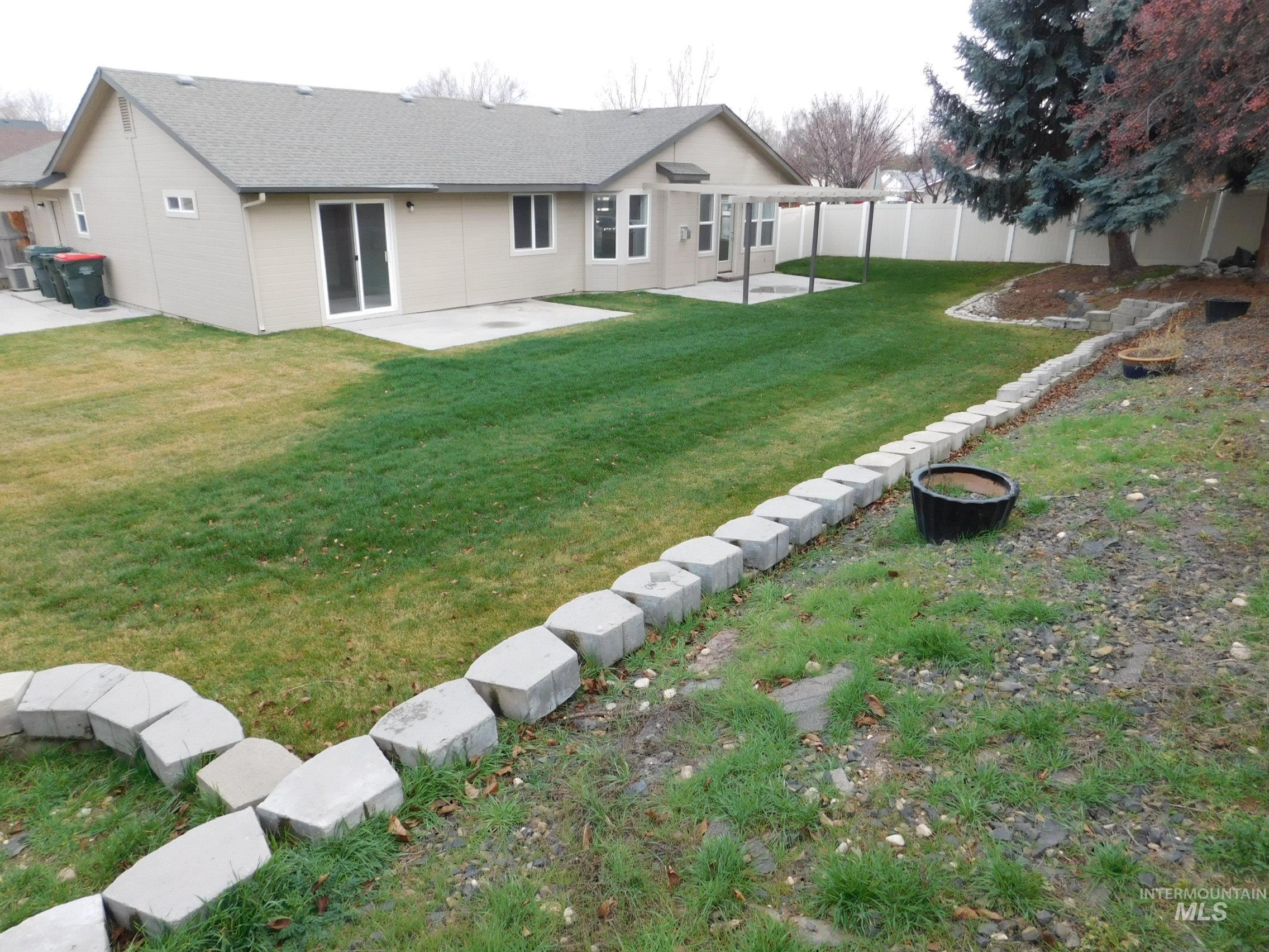 Rear view of property with a patio, a shingled roof, and a fenced backyard