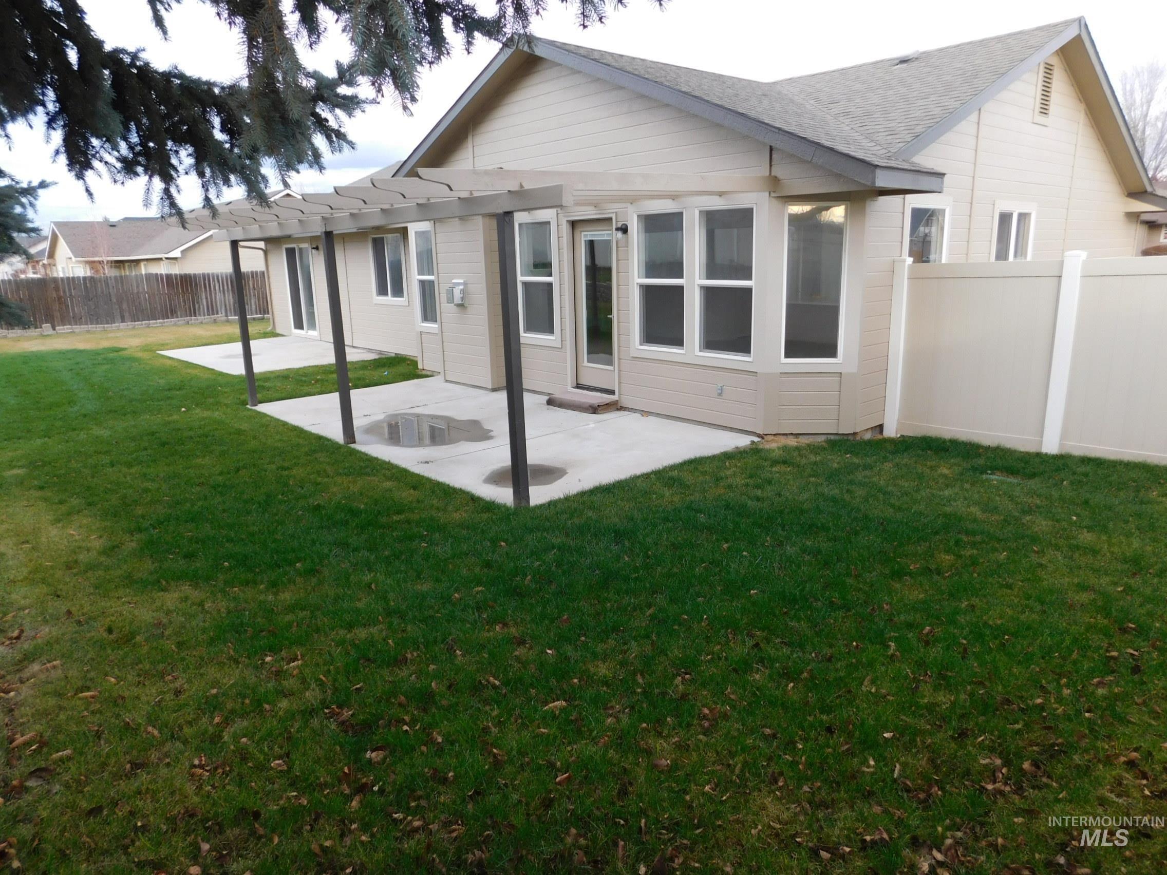 Back of property with a patio, a fenced backyard, a pergola, and a shingled roof