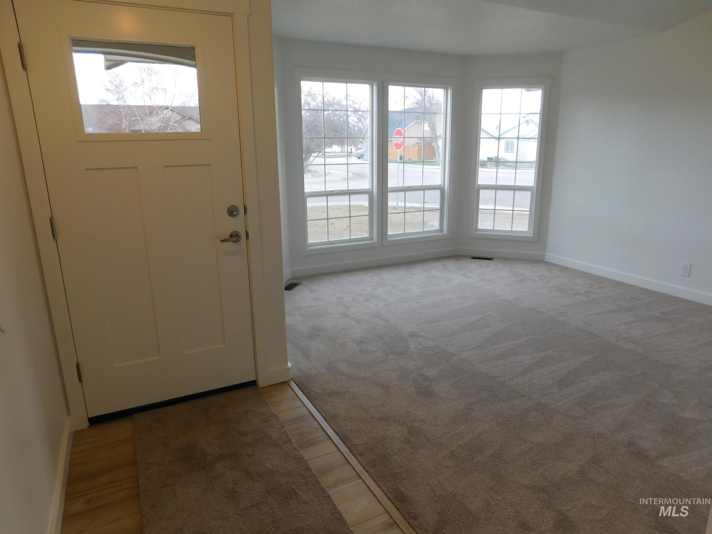 Entryway featuring baseboards and light colored carpet