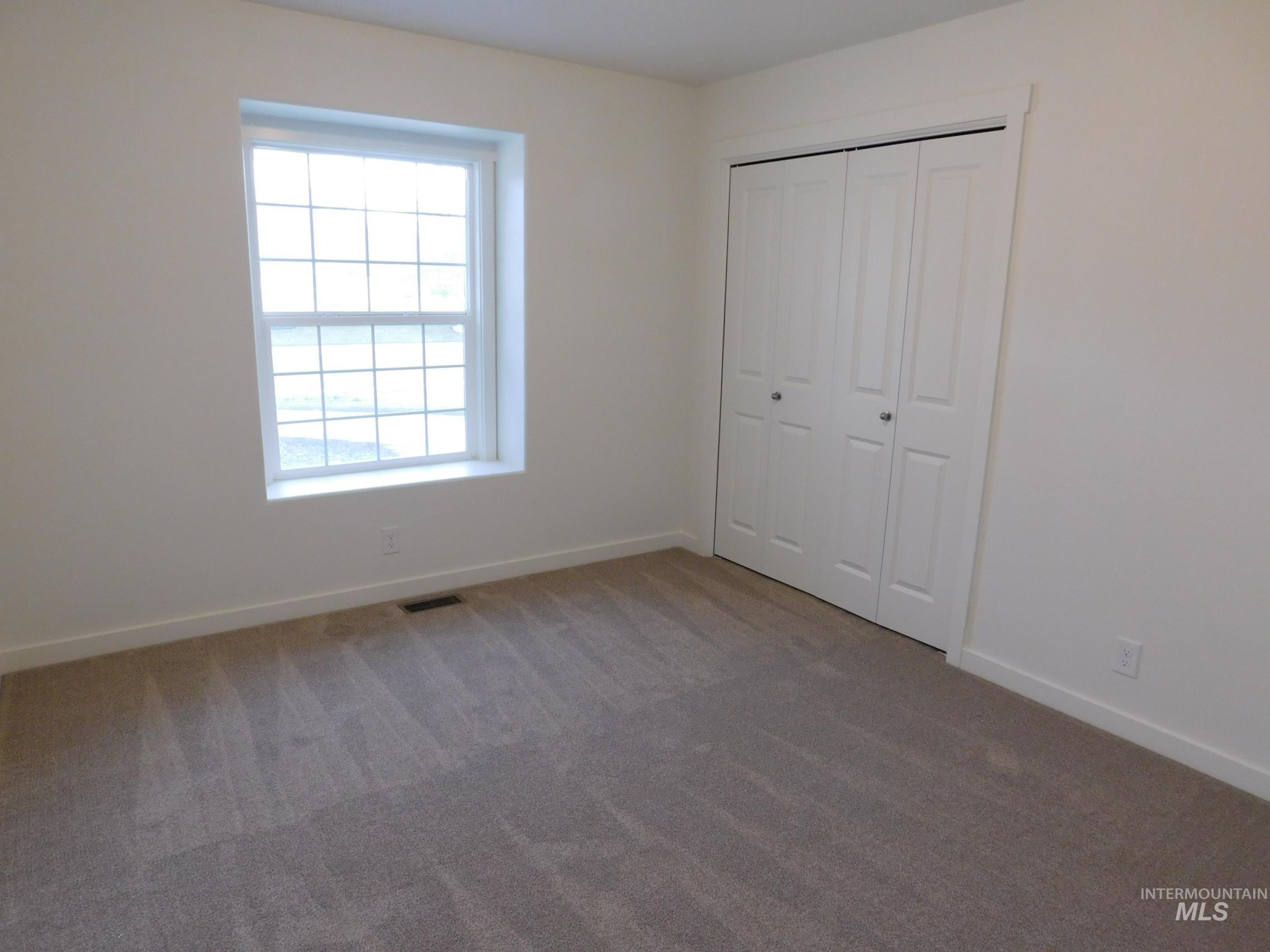 Unfurnished bedroom featuring carpet flooring and a closet