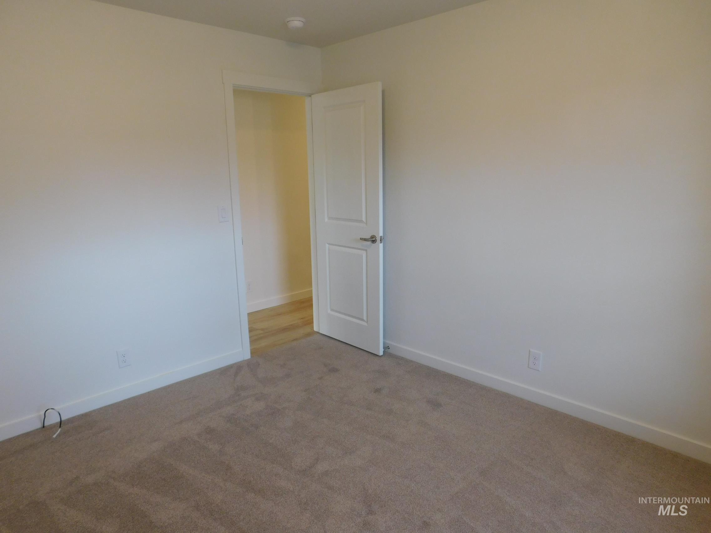 Carpeted empty room with baseboards