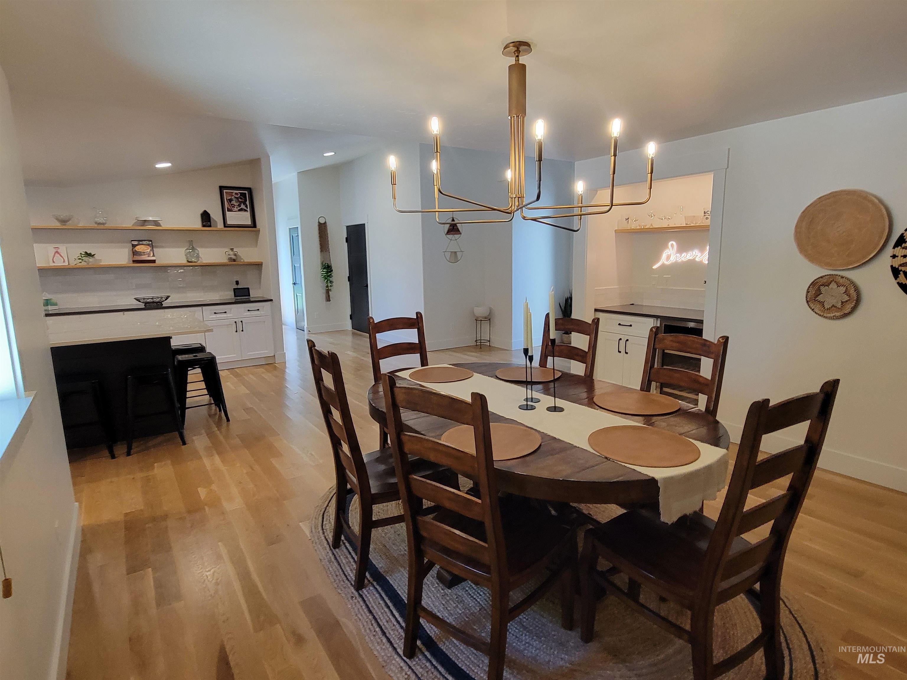 Dining space with light wood-style floors, a chandelier, and recessed lighting
