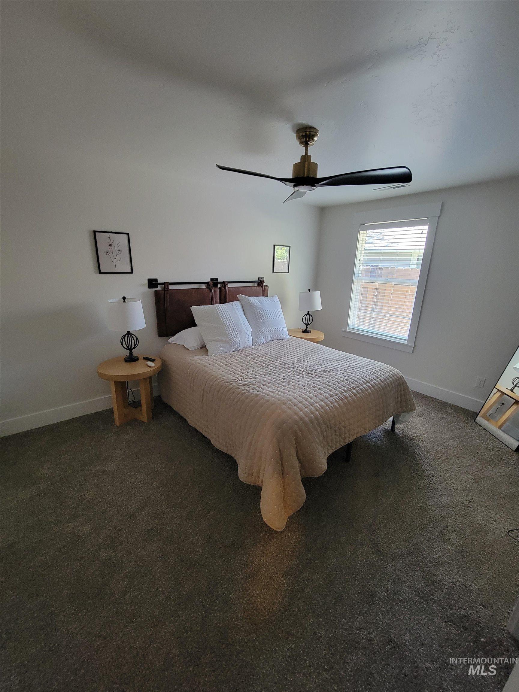 Carpeted bedroom with baseboards and ceiling fan