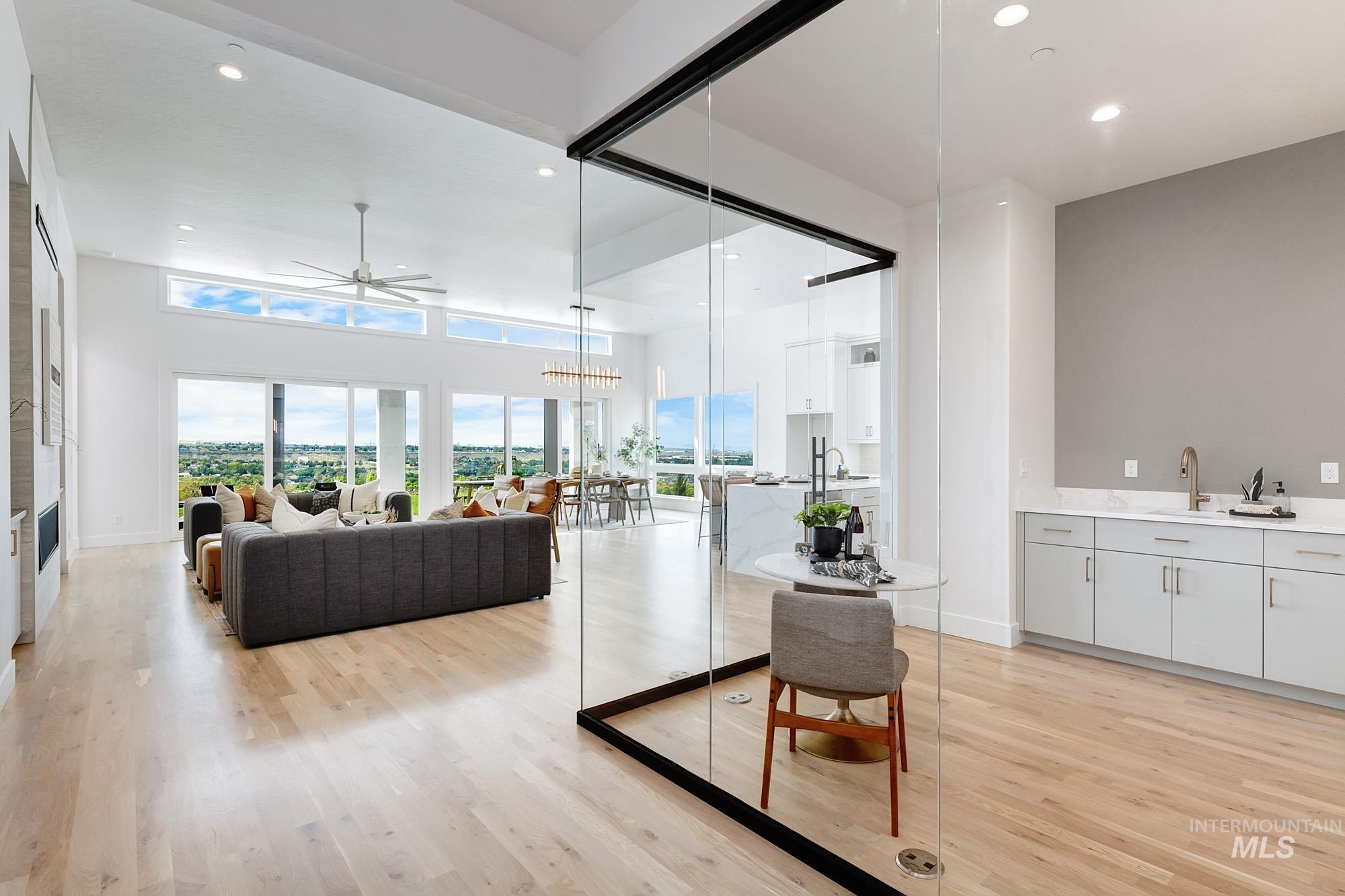 Living area with a ceiling fan, light wood-type flooring, recessed lighting, and a chandelier