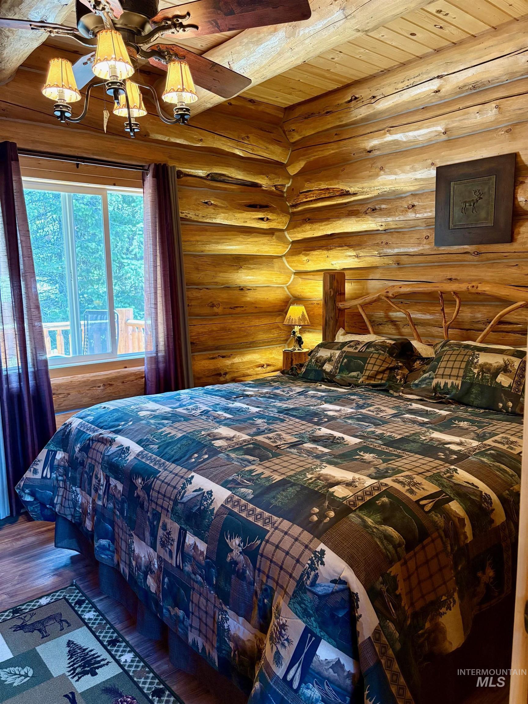 Bedroom featuring log walls, a wood ceiling with exposed beams, and hardwood / wood-style floors